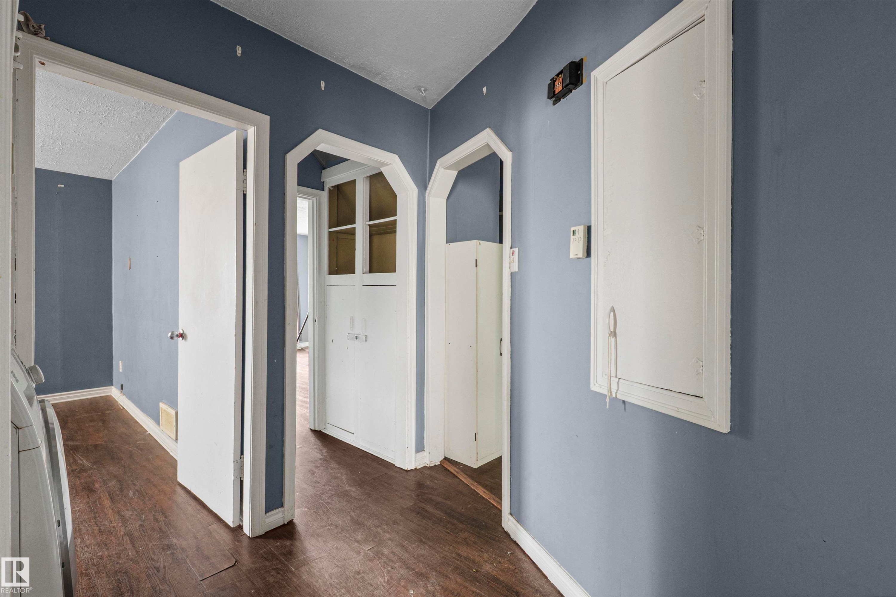 Hallway featuring wood-finish flooring and solid core doors - 7520 106 Street, Edmonton, AB