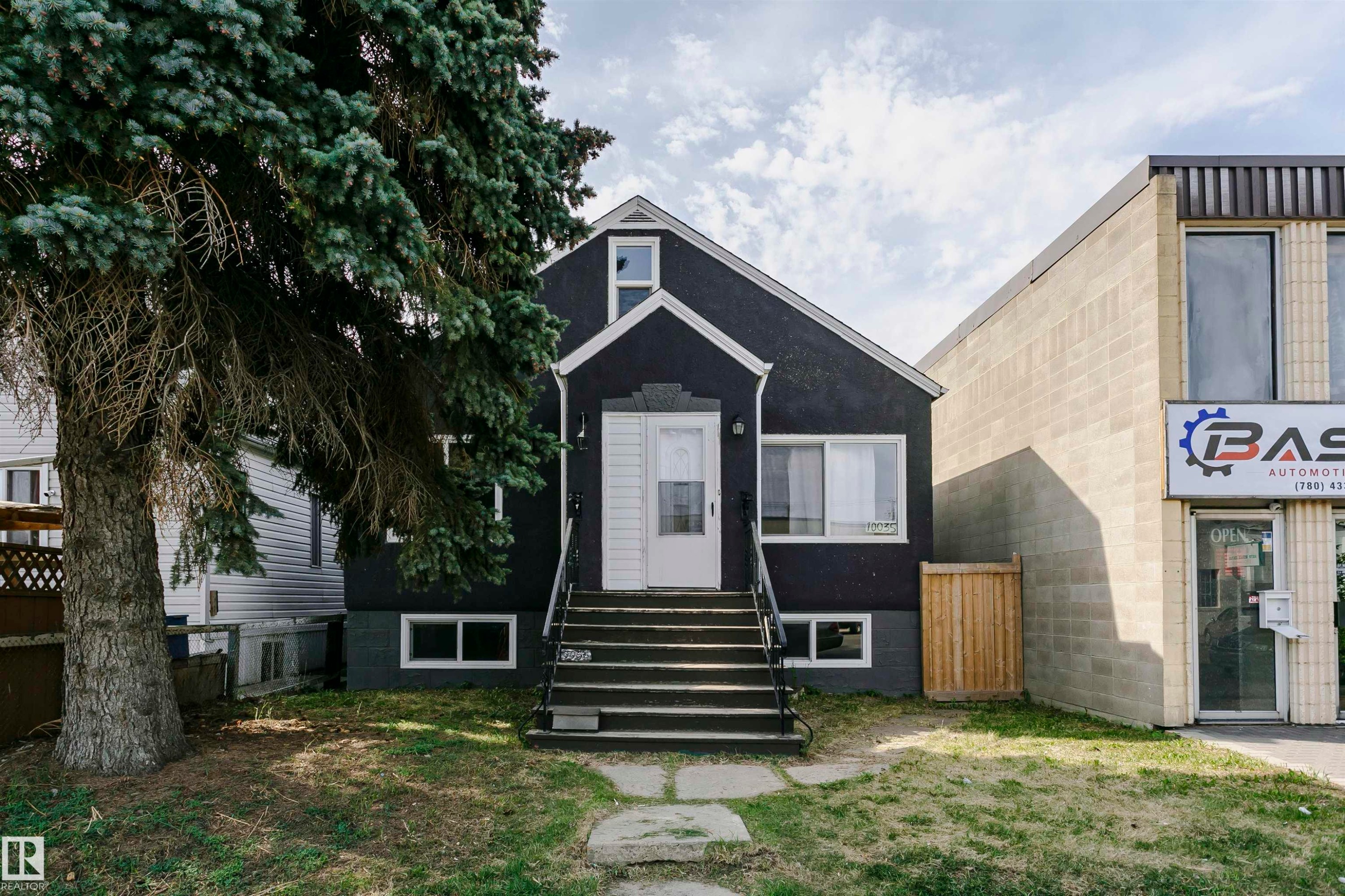 Property exterior featuring a dark stucco finish and white trim - 10035 81 Avenue Nw, Edmonton, AB - Outdoor