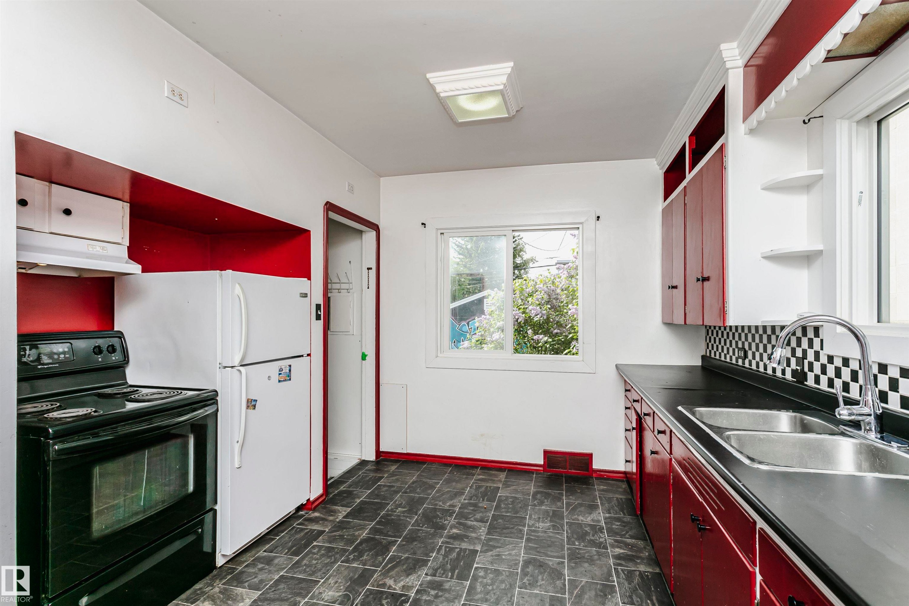 Kitchen featuring dark grey tile flooring and bright red lower cabinetry - 10035 81 Avenue Nw, Edmonton, AB - Indoor Photo Showing Kitchen With Double Sink