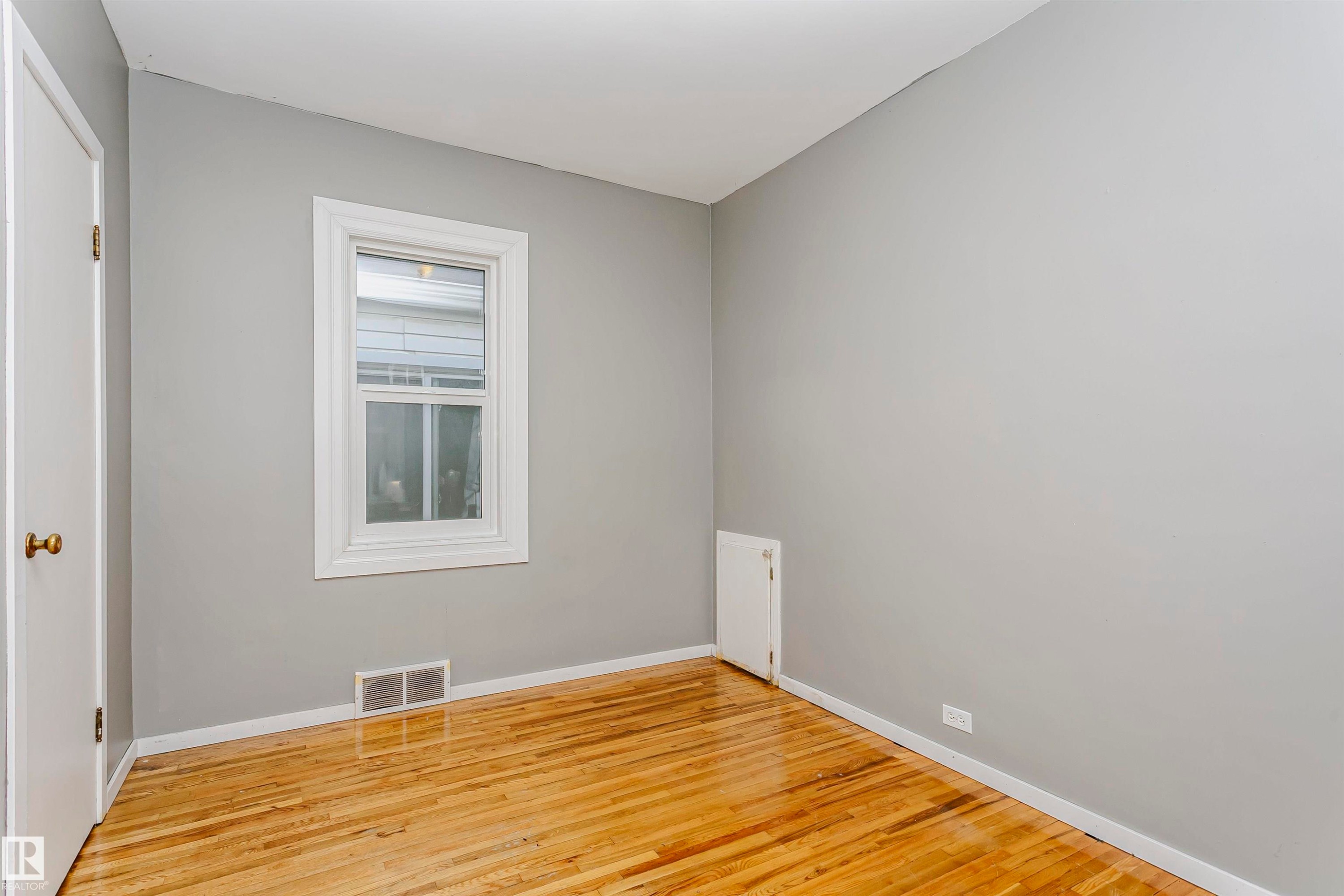 Hardwood flooring, light gray wall paint, and white trim - 10035 81 Avenue Nw, Edmonton, AB - Indoor Photo Showing Other Room