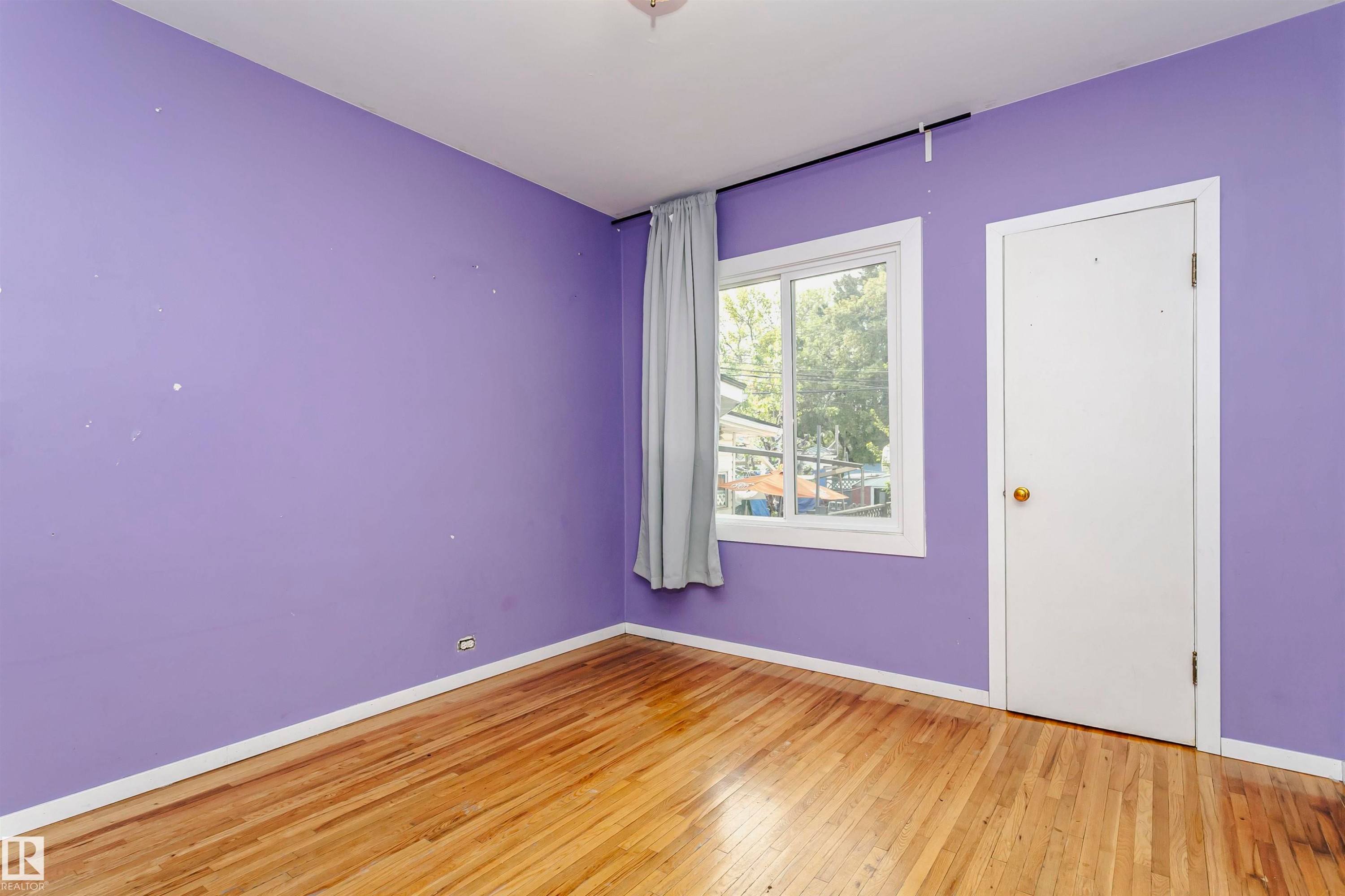 Hardwood flooring and a white trim baseboard - 10035 81 Avenue Nw, Edmonton, AB - Indoor Photo Showing Other Room