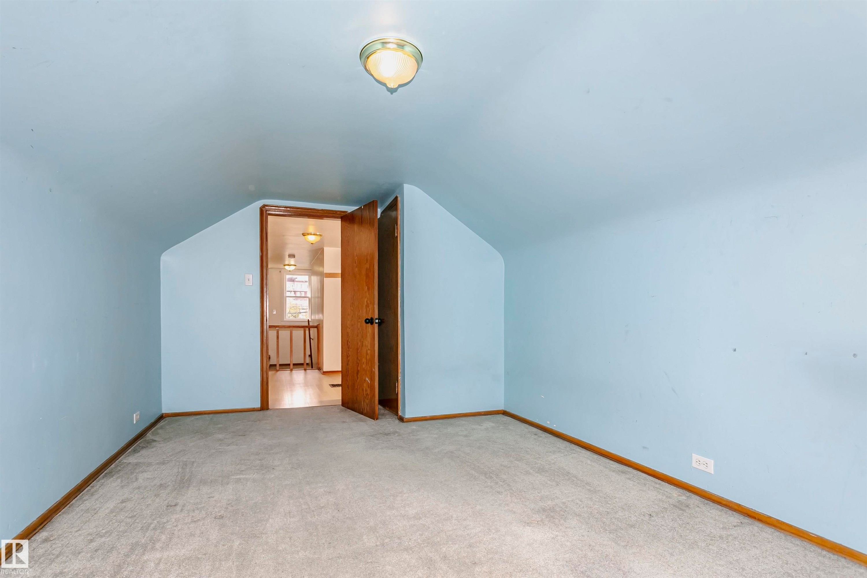 Room with light blue walls, sloped ceilings, and neutral carpet flooring - 10035 81 Avenue Nw, Edmonton, AB - Indoor Photo Showing Other Room