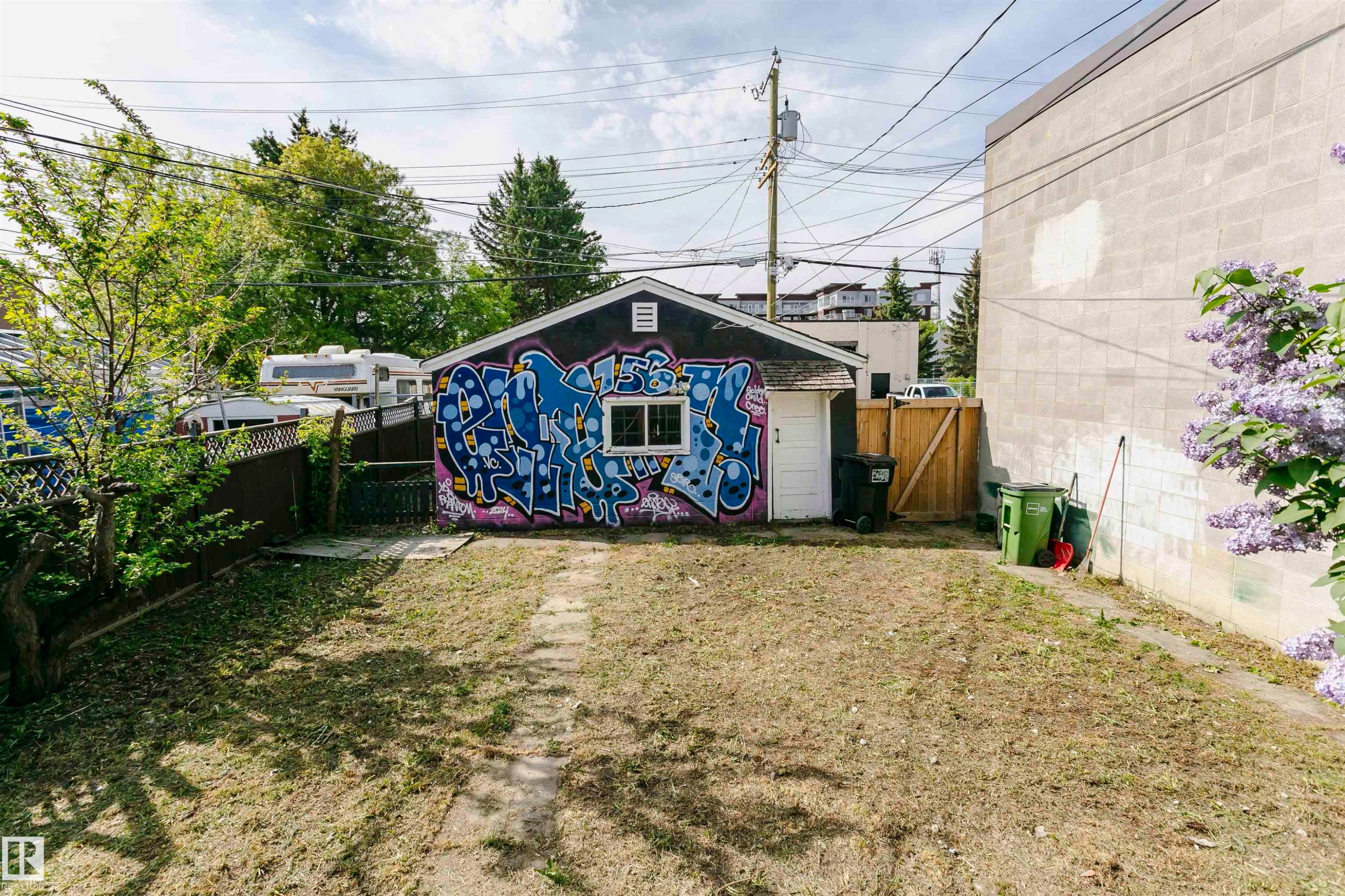 Detached garage building featuring a side entry door and a window, situated within a partially fenced yard - 10035 81 Avenue Nw, Edmonton, AB - Outdoor