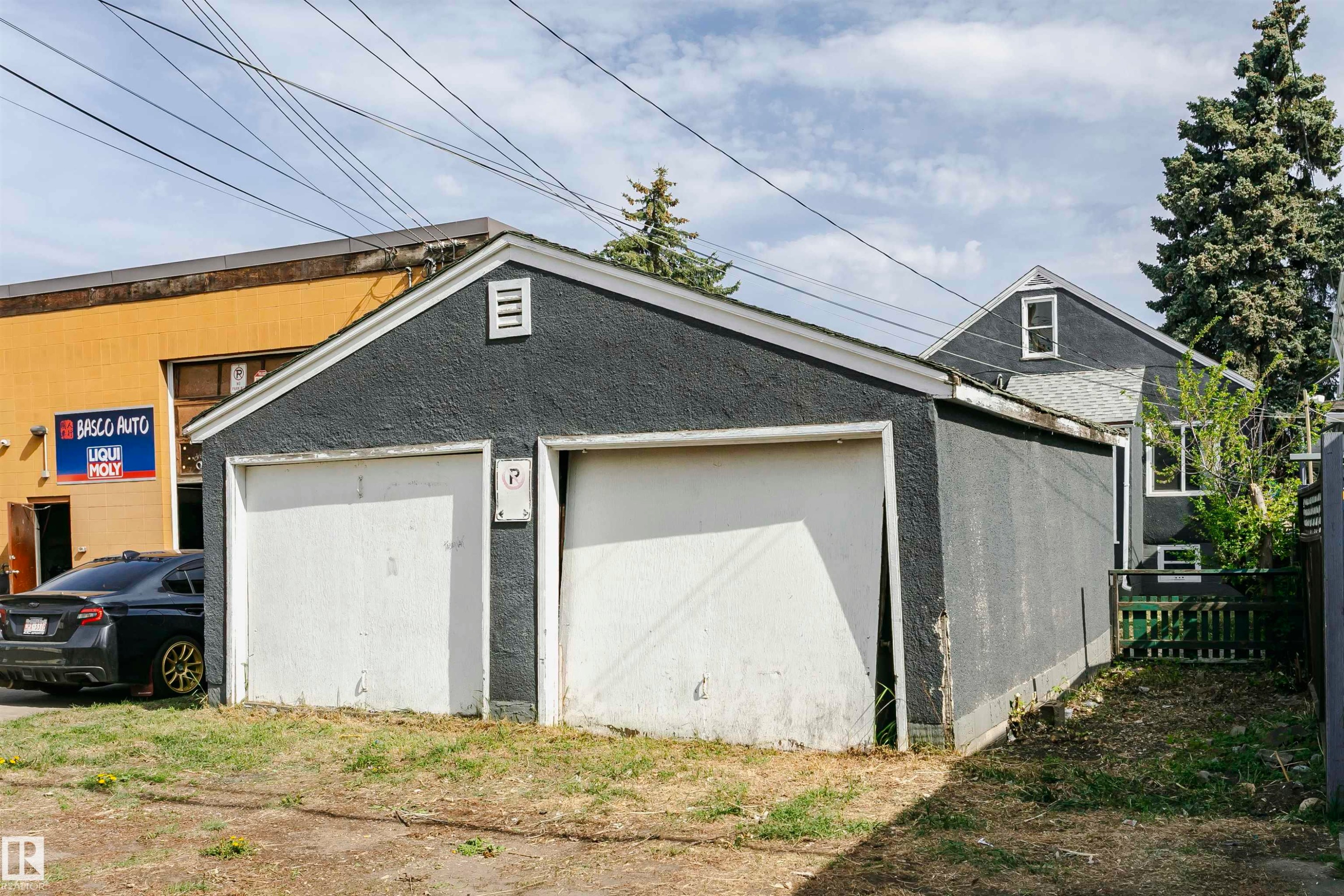 Detached two-car garage with white garage doors and a grey stucco exterior - 10035 81 Avenue Nw, Edmonton, AB - Outdoor