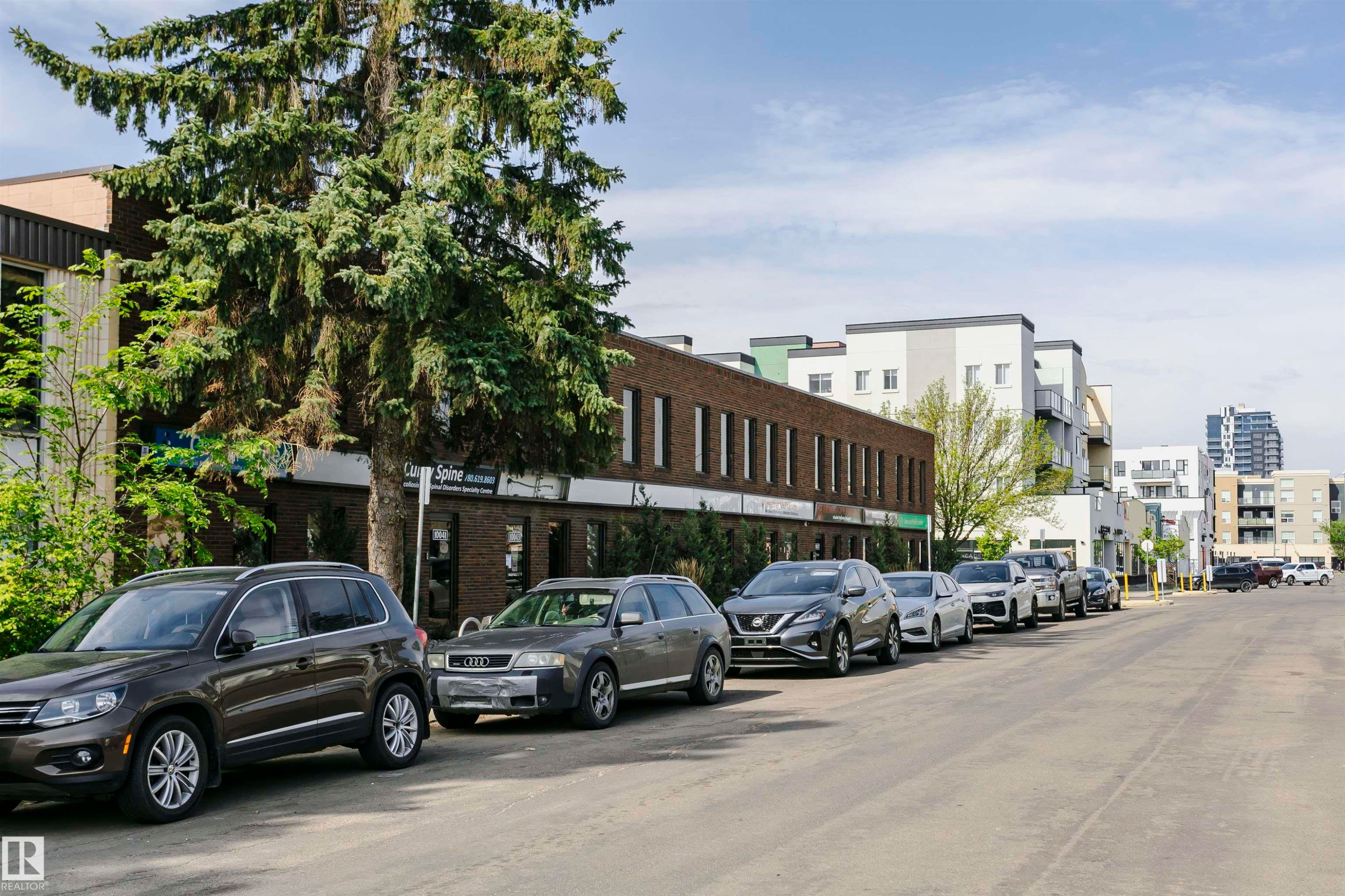 Streetscape featuring a multi-story brick building with commercial storefronts and upper-level windows - 10035 81 Avenue Nw, Edmonton, AB - Outdoor