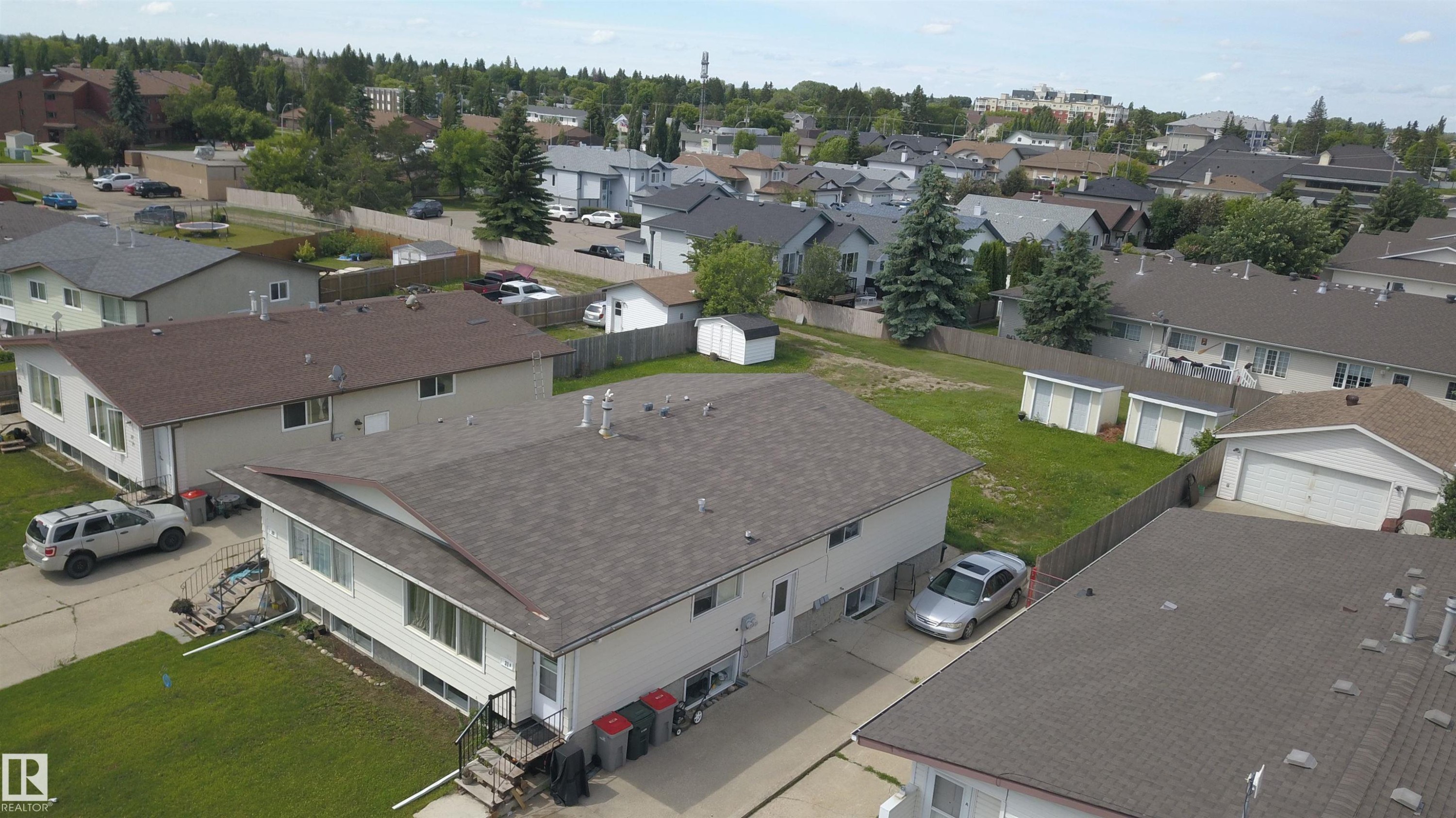 Residential property featuring a light-colored exterior and a dark shingle roof - 31 Brown Street, Stony Plain, AB