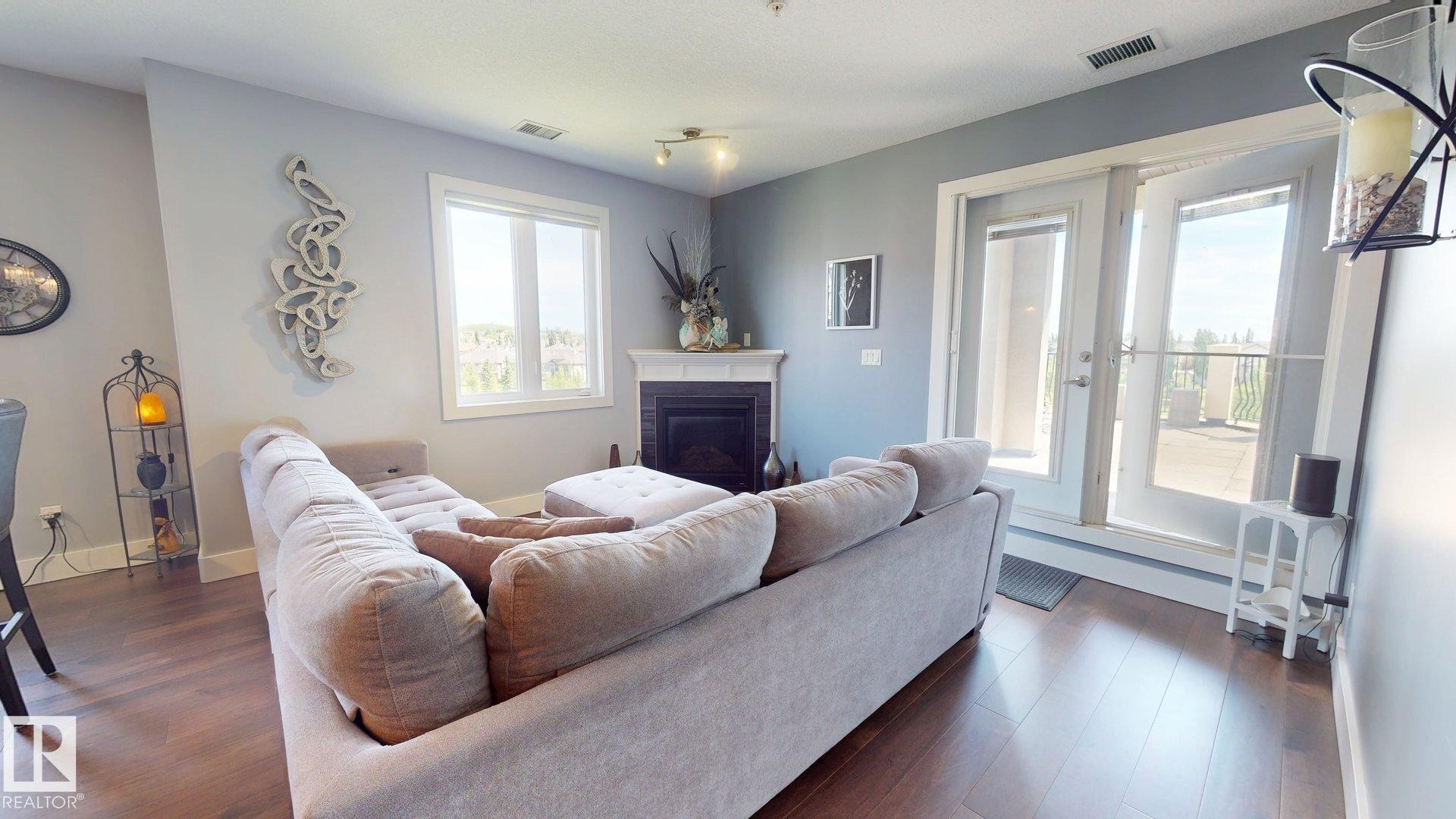 #355 6079 Maynard Wy Nw, Edmonton, AB - Indoor Photo Showing Living Room With Fireplace