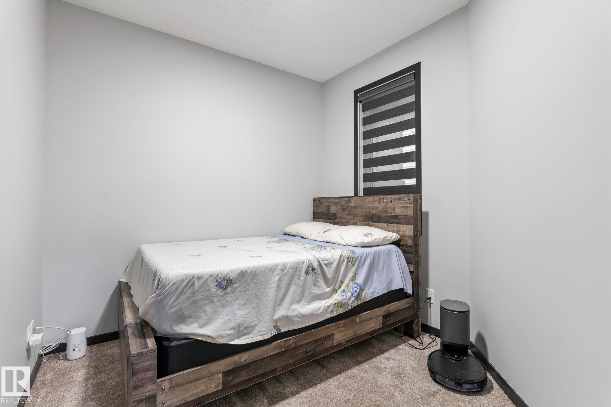 Neutral gray walls with dark trim detail frame a window with horizontal blinds - 5110 23A Ave Sw, Edmonton, AB