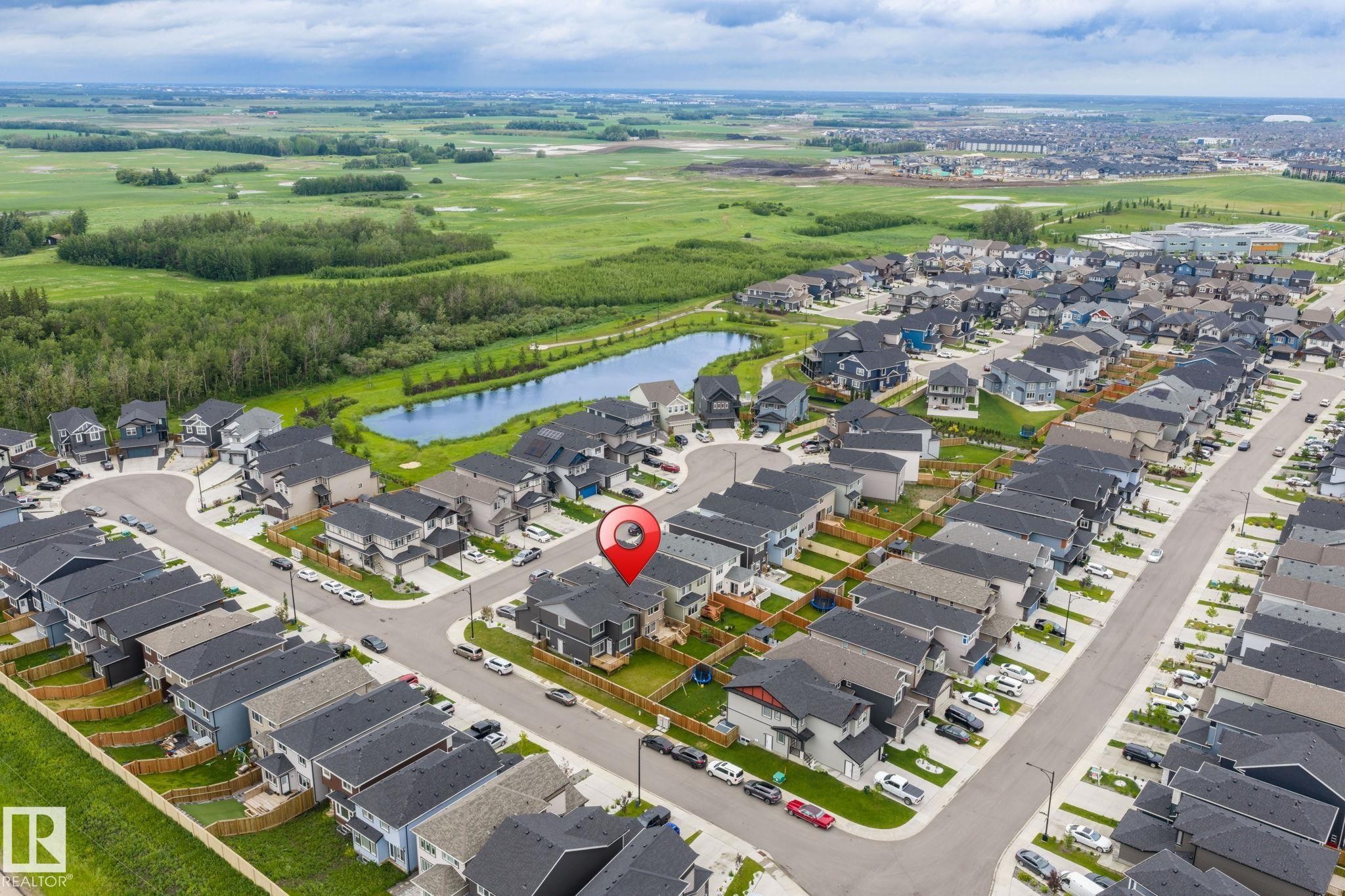 Aerial perspective of a modern residential development featuring numerous detached homes with dark roofs and light-toned siding - 5110 23A Ave Sw, Edmonton, AB