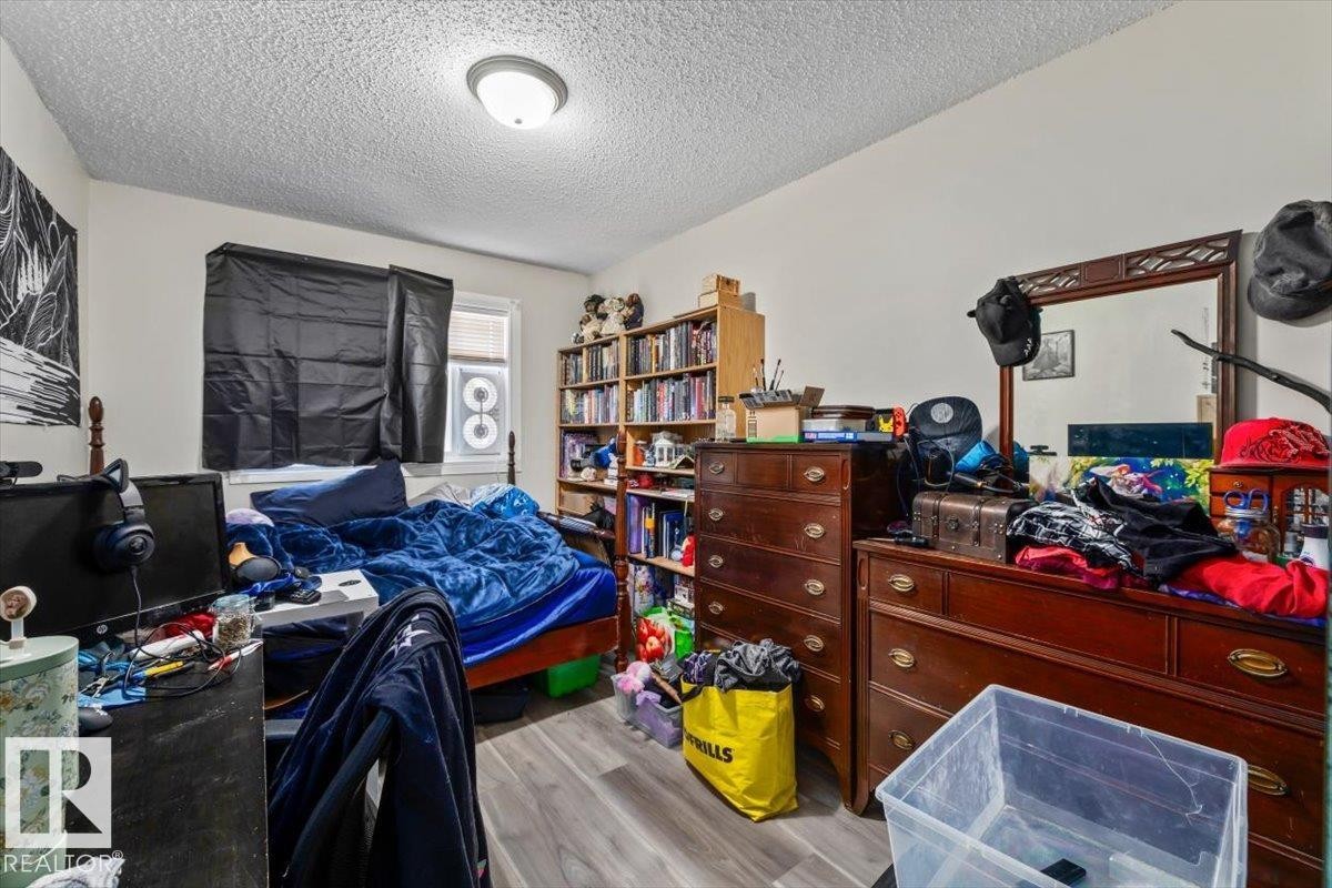 Neutral wall paint, textured ceiling, and wood-finish flooring define this interior space - #202 10330 113 St Nw, Edmonton, AB