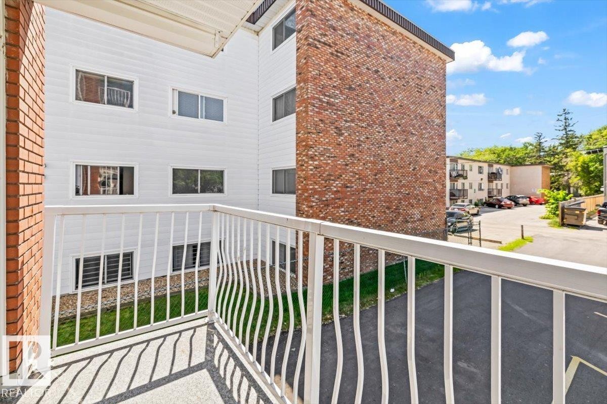 Private balcony with white metal railing and a concrete floor - #202 10330 113 St Nw, Edmonton, AB