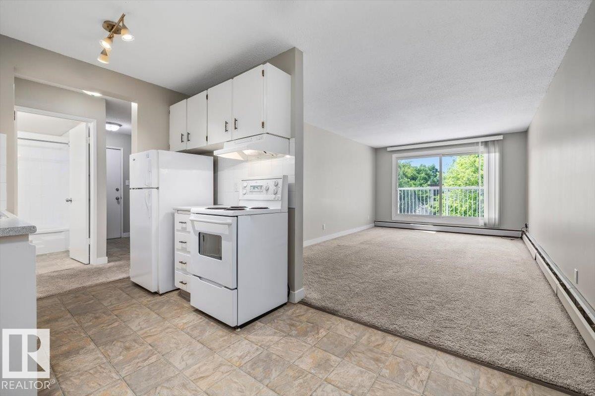 Kitchen featuring white cabinetry, white appliances, and tiled flooring - #306 10330 113 St Nw, Edmonton, AB