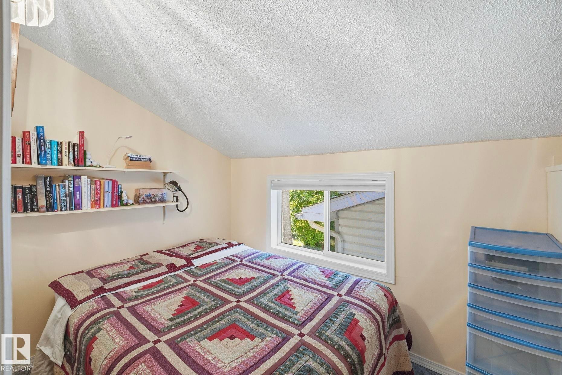 Room featuring angled ceilings, light-toned walls, and a single window with white trim - 1410 47436 Range Rd. 15, Rural Leduc County, AB