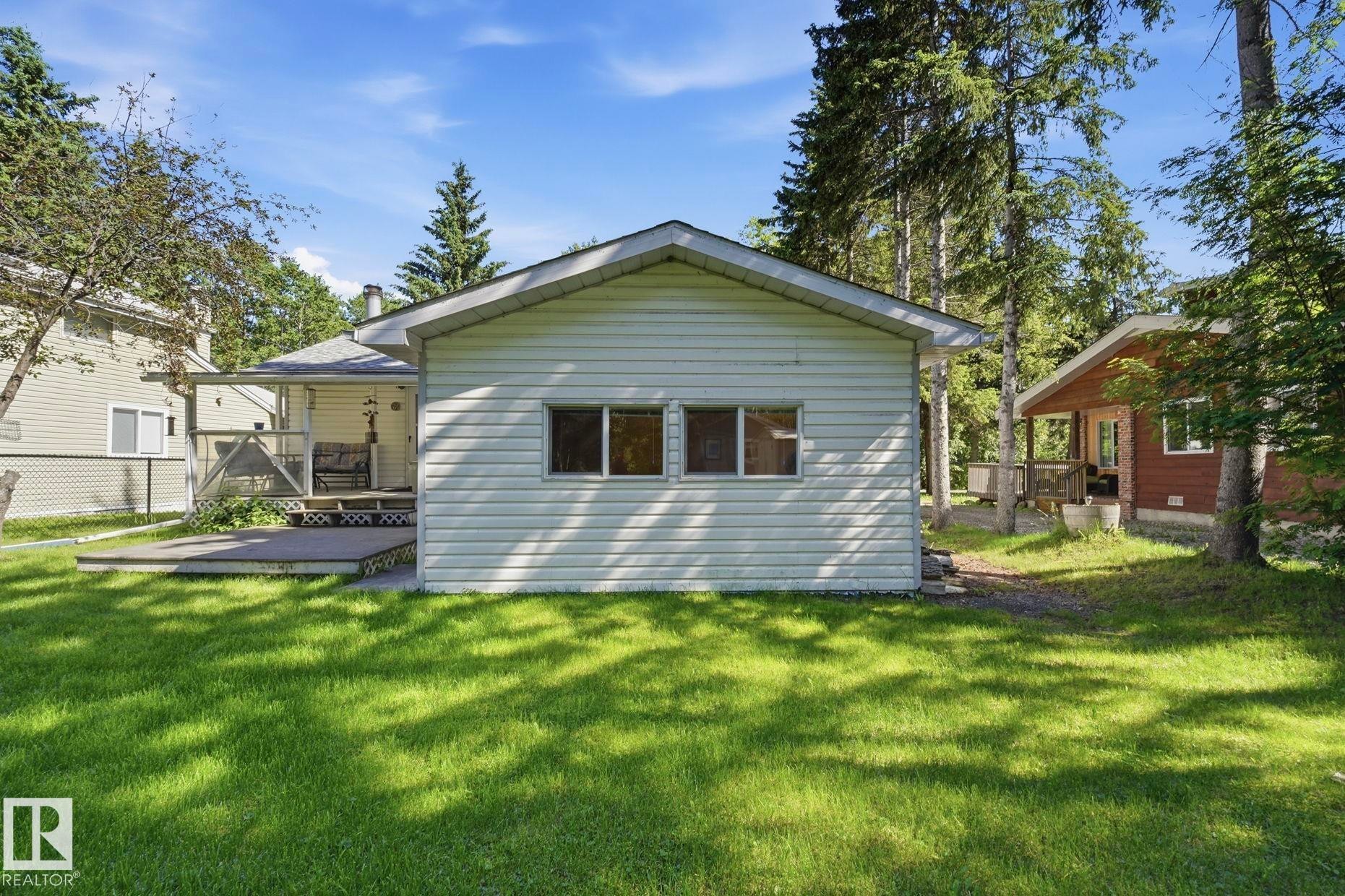 Exterior siding with multiple windows, surrounded by mature trees - 1410 47436 Range Rd. 15, Rural Leduc County, AB