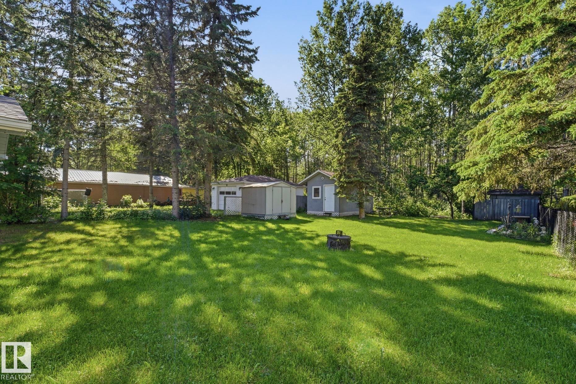 Expansive grass lawn featuring mature trees - 1410 47436 Range Rd. 15, Rural Leduc County, AB