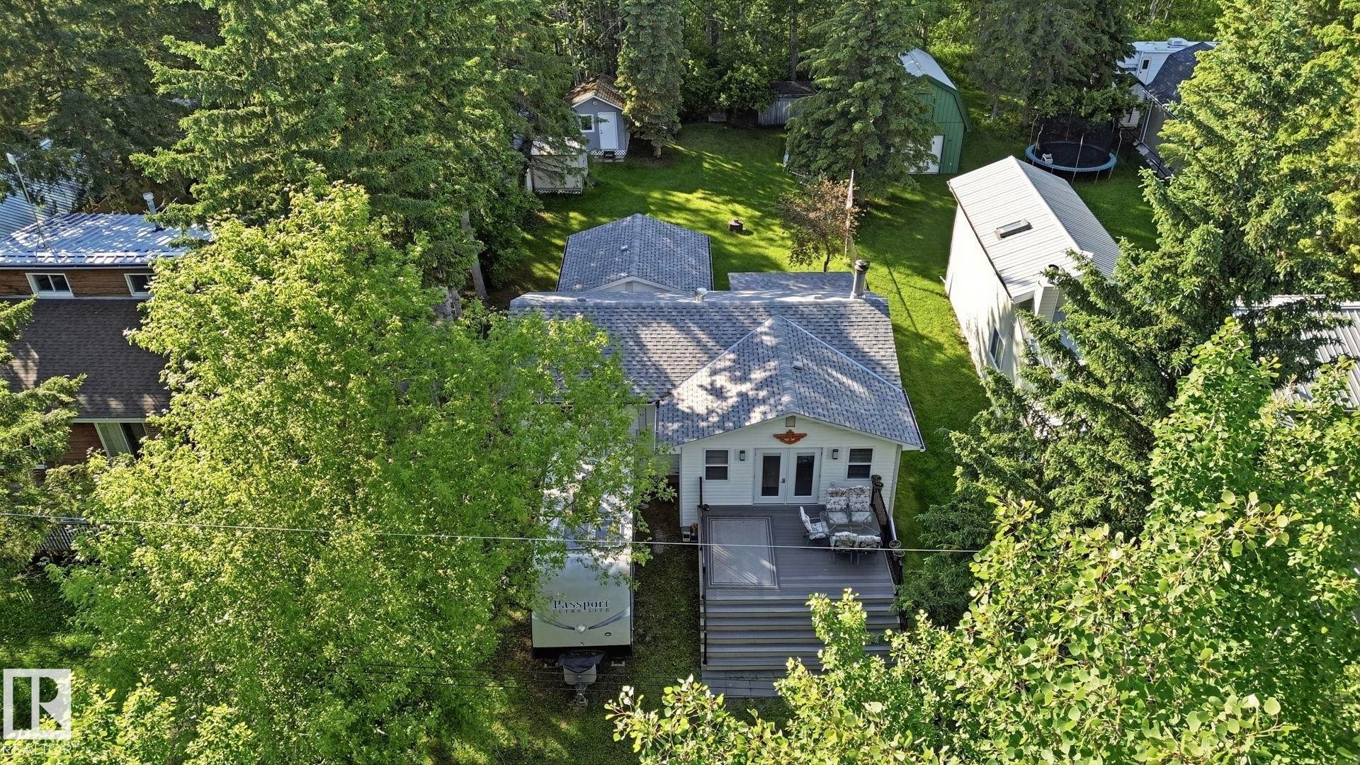 Rear exterior featuring an elevated deck with steps to the yard, white siding, and a gabled roof - 1410 47436 Range Rd. 15, Rural Leduc County, AB