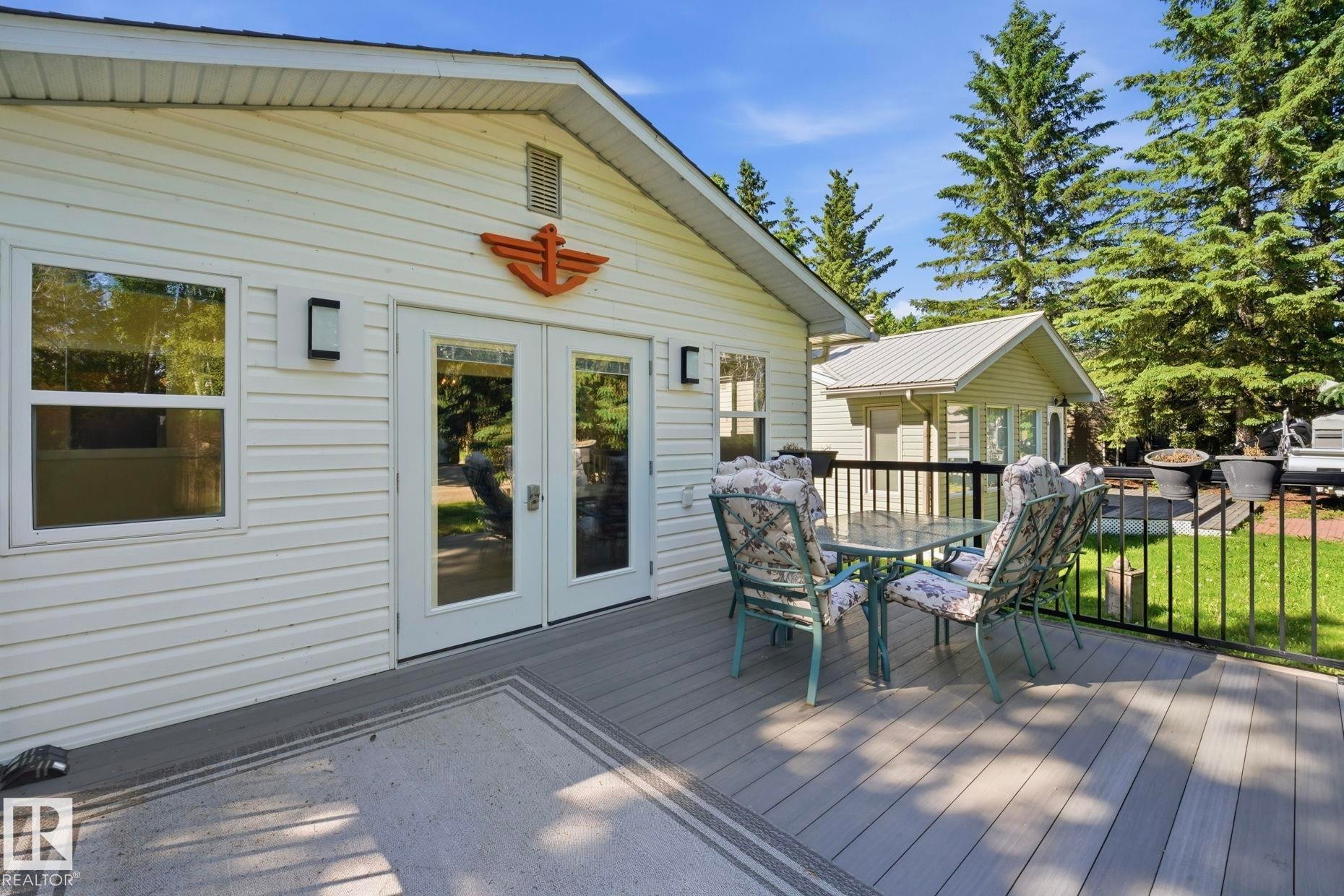 Expansive composite deck featuring a black metal railing and direct access via double French doors - 1410 47436 Range Rd. 15, Rural Leduc County, AB