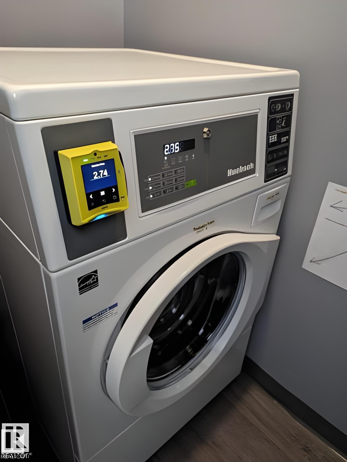 Stackable laundry appliances featuring a front-loading washer and integrated payment system - 611 12831 66 Street, Edmonton, AB