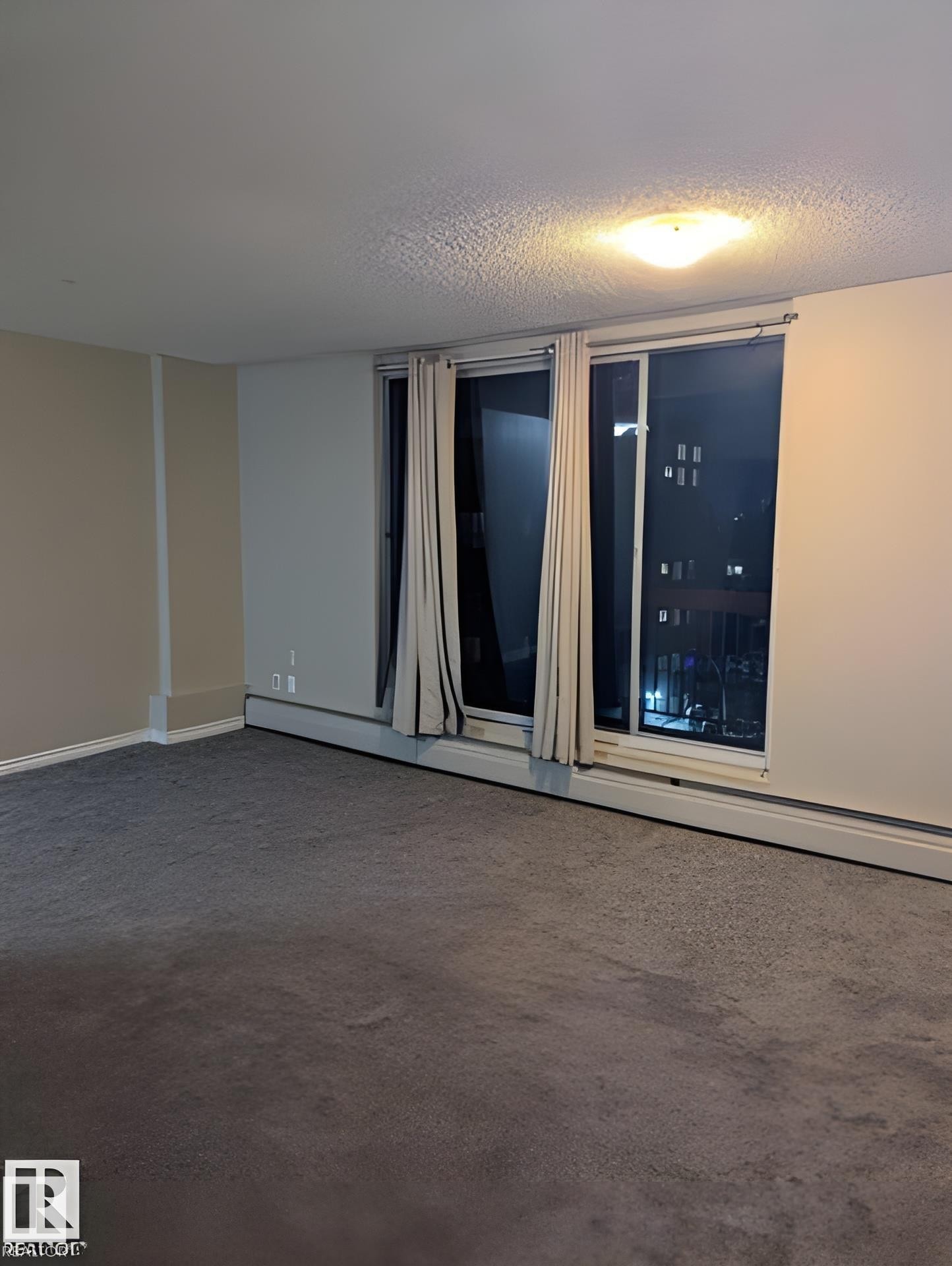 Wall-to-wall carpeting in a neutral tone, complemented by a large window feature with vertical blinds - 611 12831 66 Street, Edmonton, AB