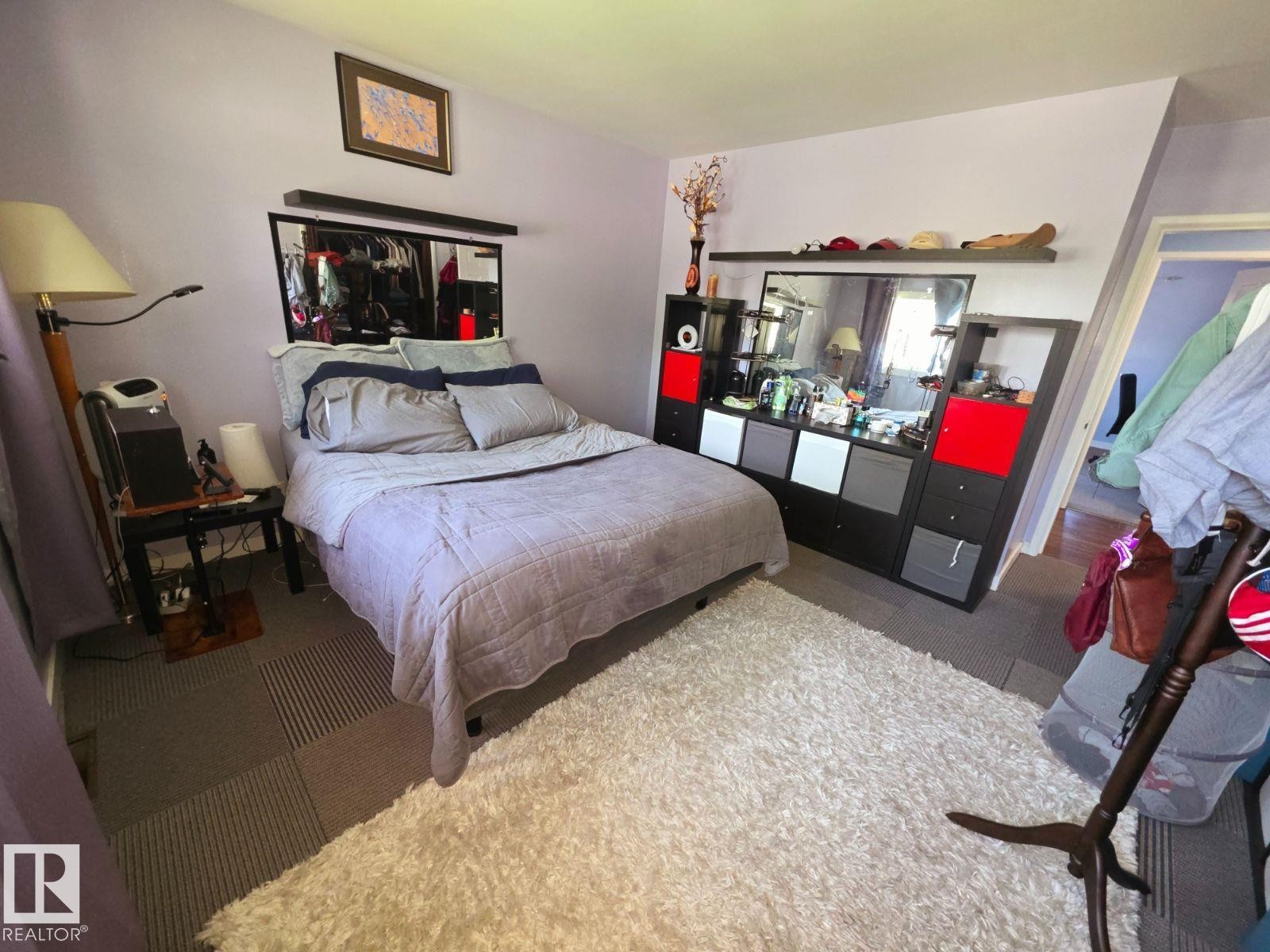 Bedroom featuring light-toned wall paint and patterned carpet tiles - 10404 116 Avenue, Edmonton, AB