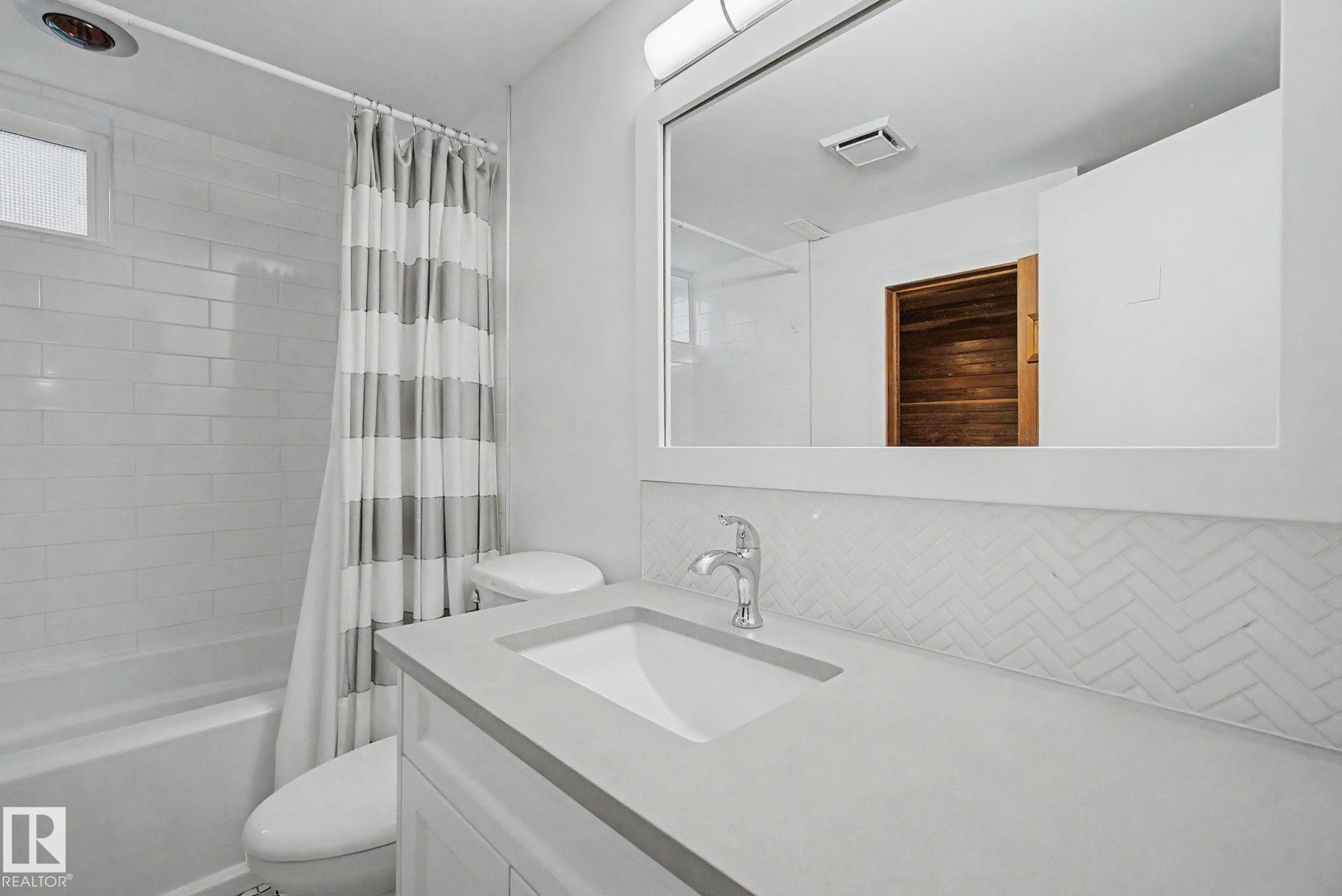 Bathroom featuring a white vanity with an integrated sink, polished chrome faucet, and light gray countertop - 170 Westridge Rd, Edmonton, AB - Indoor Photo Showing Bathroom