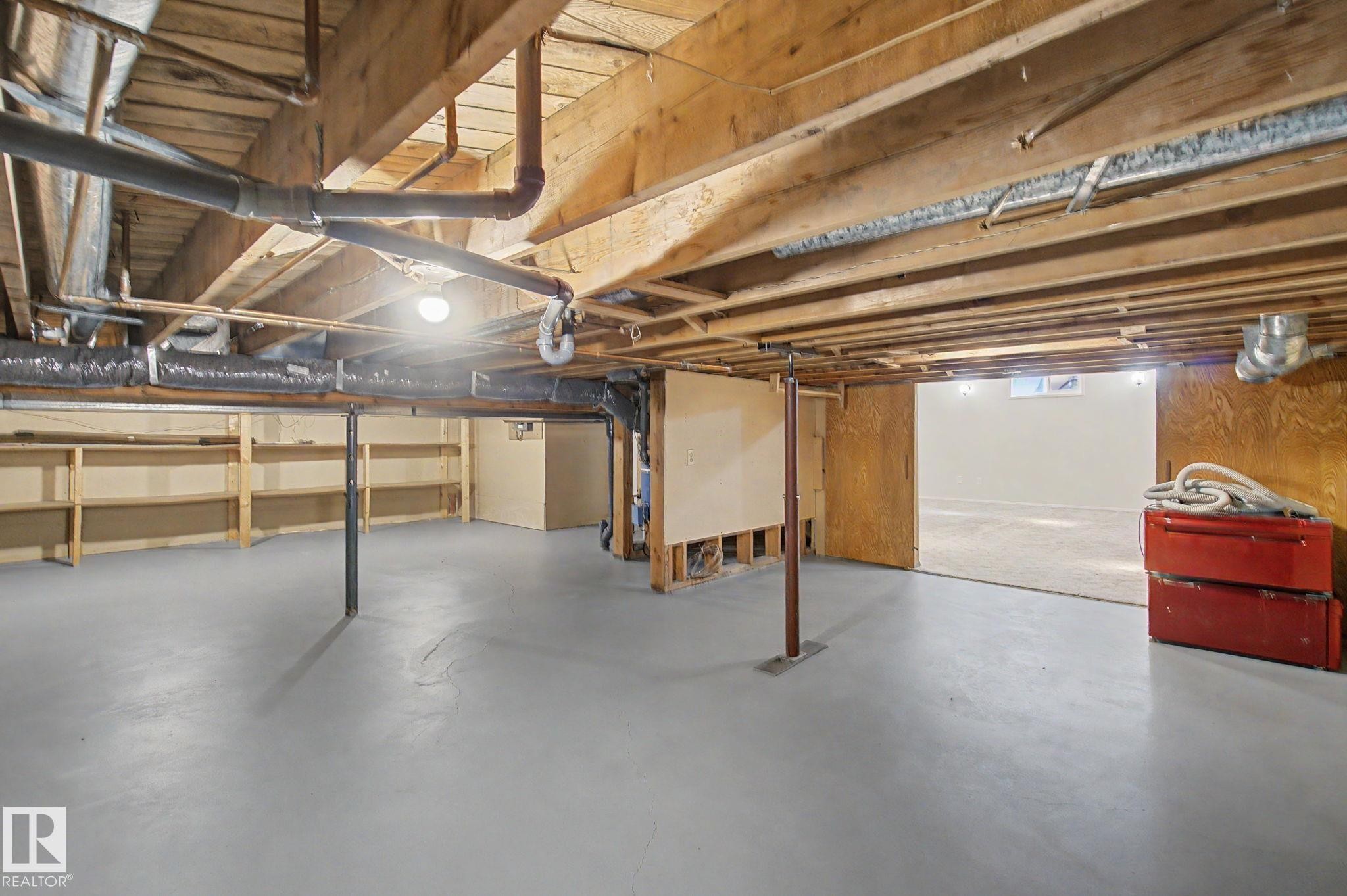 Basement space featuring exposed wood joists, structural support columns, and built-in shelving - 170 Westridge Rd, Edmonton, AB - Indoor Photo Showing Basement