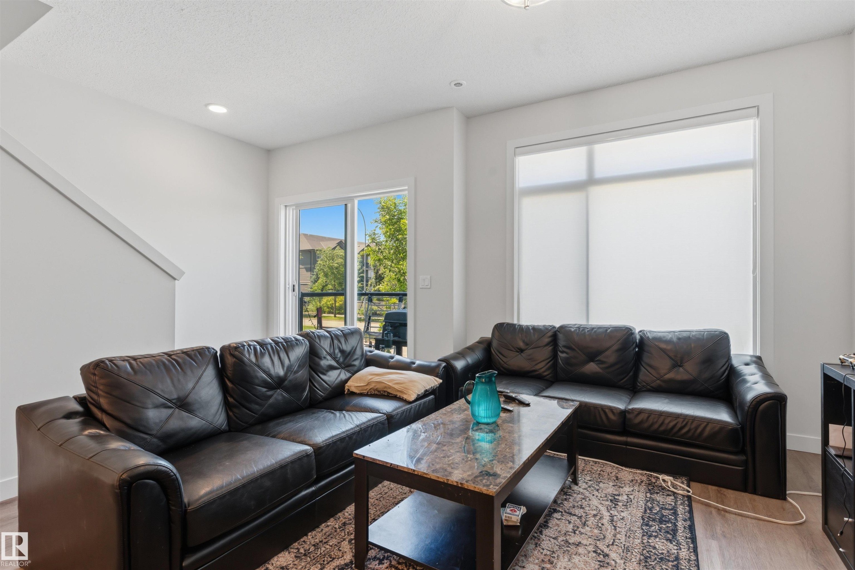 Bright living area featuring white walls, recessed lighting, and wood-finish flooring - 170 804 Welsh Drive, Edmonton, AB