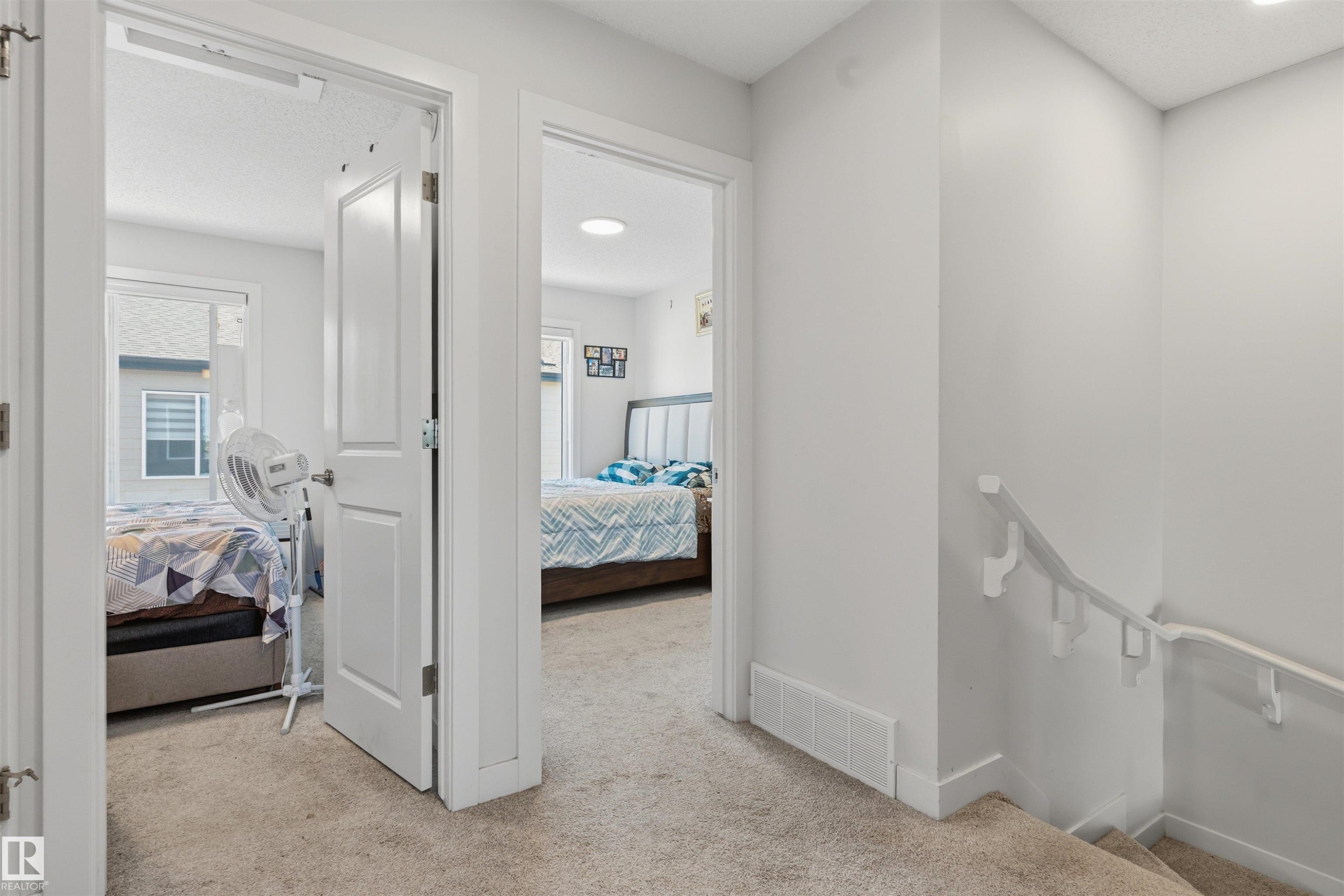 Neutral-toned carpeted hallway with white interior doors and trim - 170 804 Welsh Drive, Edmonton, AB