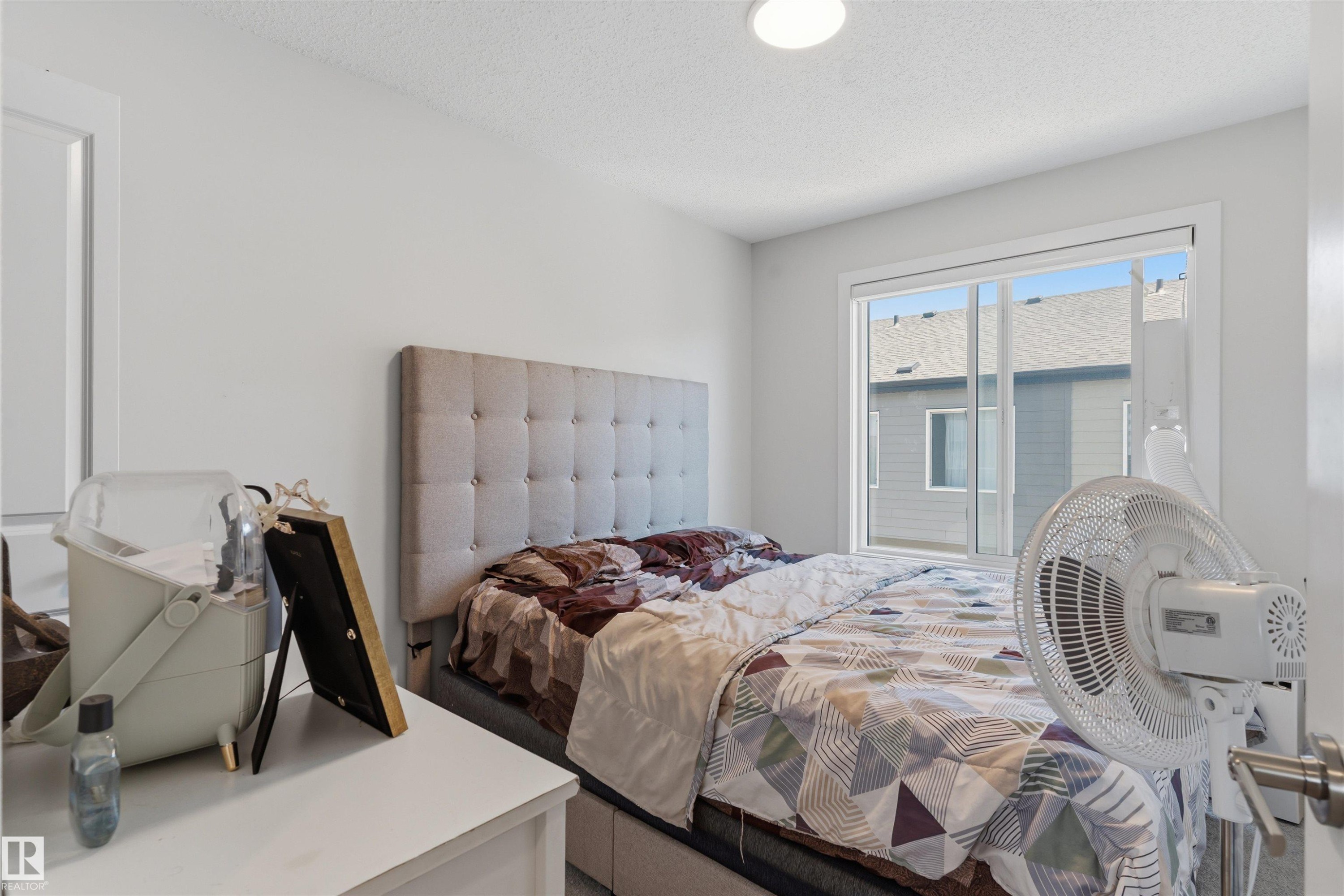 Bedroom featuring a sliding window, white walls, and a flush-mount ceiling light - 170 804 Welsh Drive, Edmonton, AB