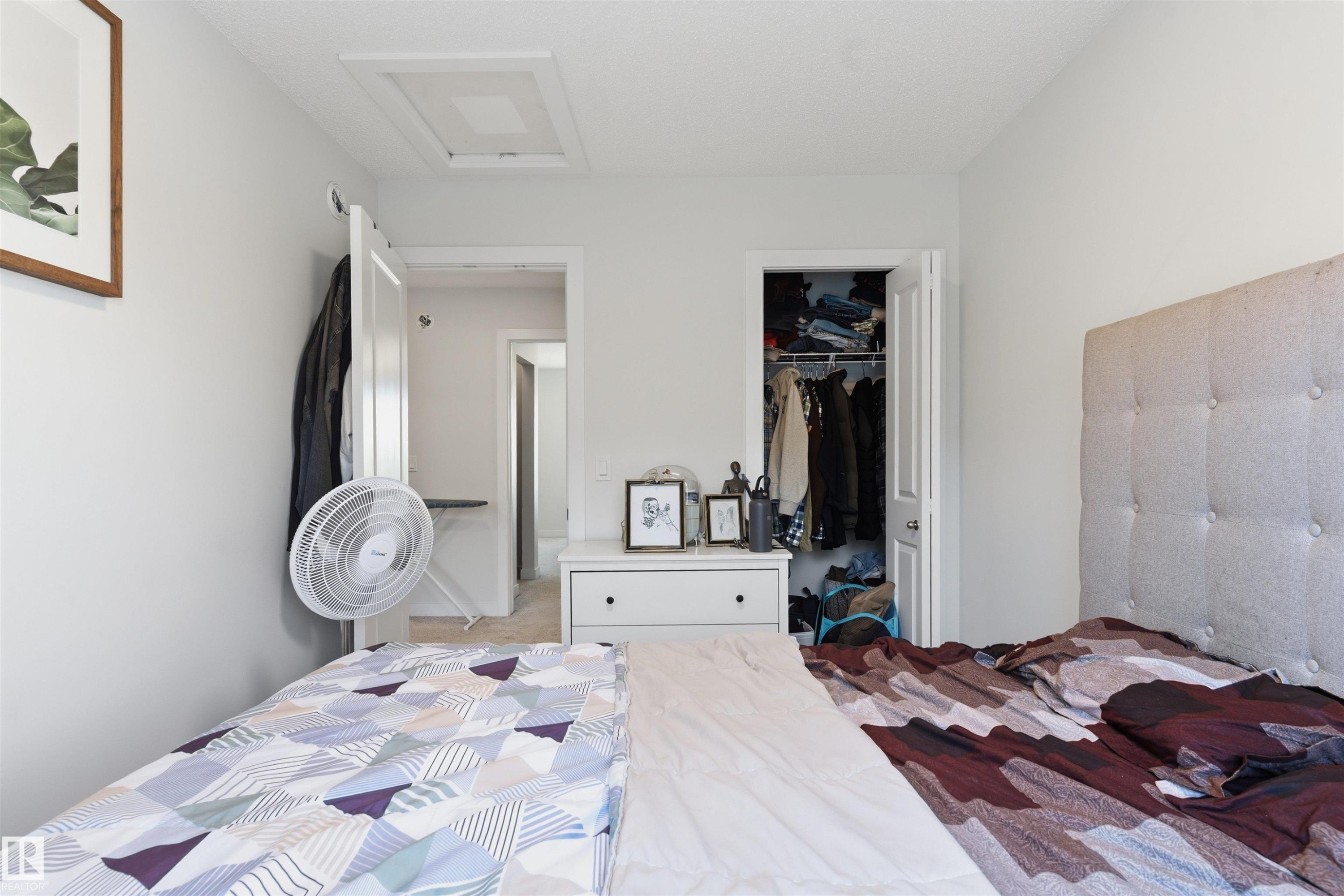Bright interior room featuring a built-in closet with bifold door, white walls, and a ceiling-mounted light fixture - 170 804 Welsh Drive, Edmonton, AB