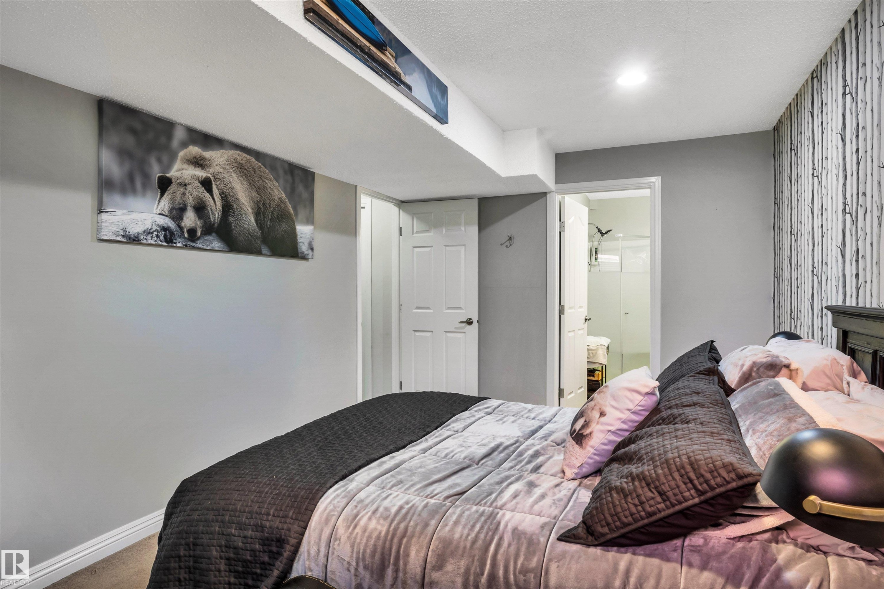 Bedroom featuring recessed lighting, a built-in closet with a white paneled door, and a textured accent wall - 9804 145 Avenue, Edmonton, AB