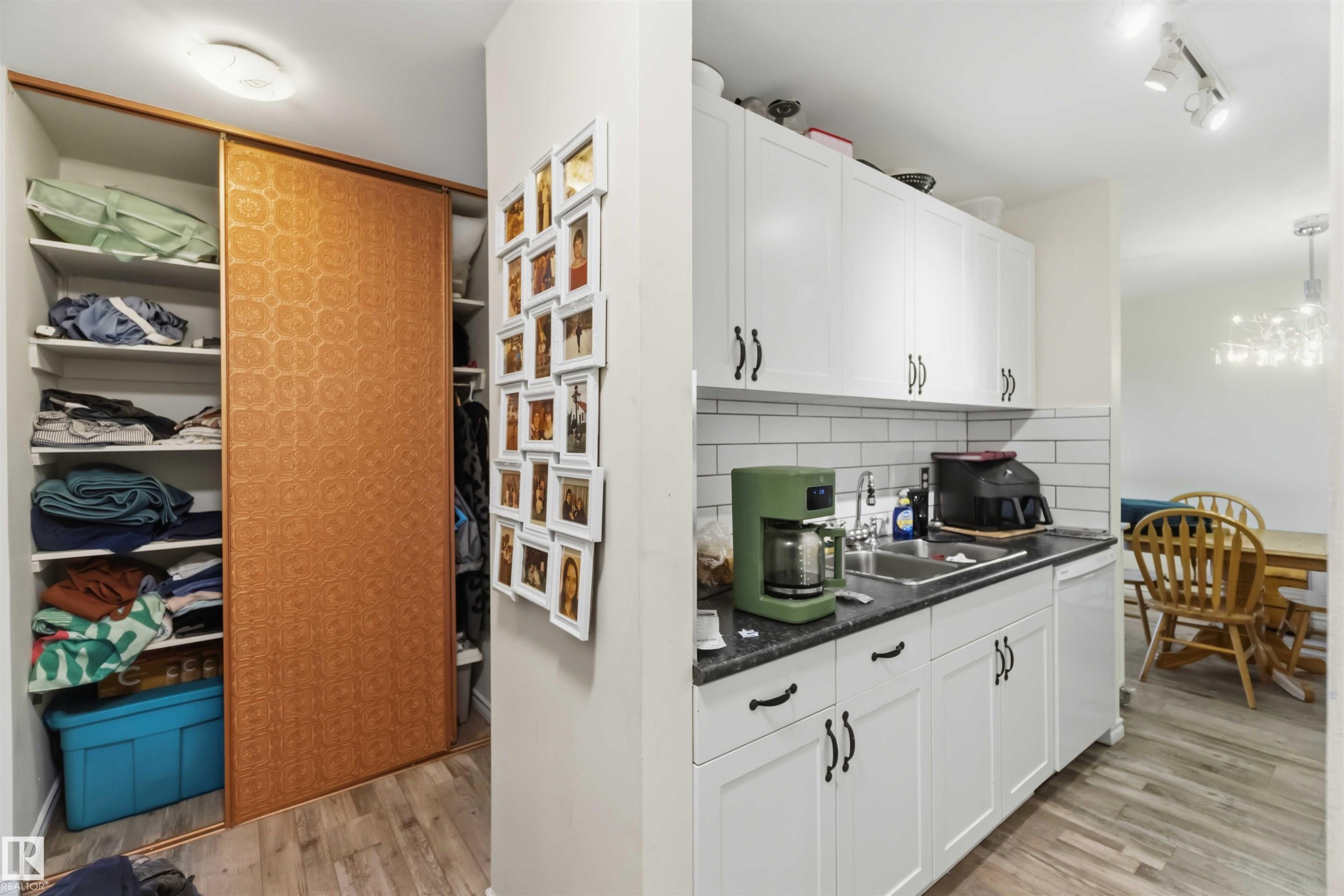 Kitchen with white cabinetry, dark countertops, and white subway tile backsplash - 204 4601 131 Avenue, Edmonton, AB