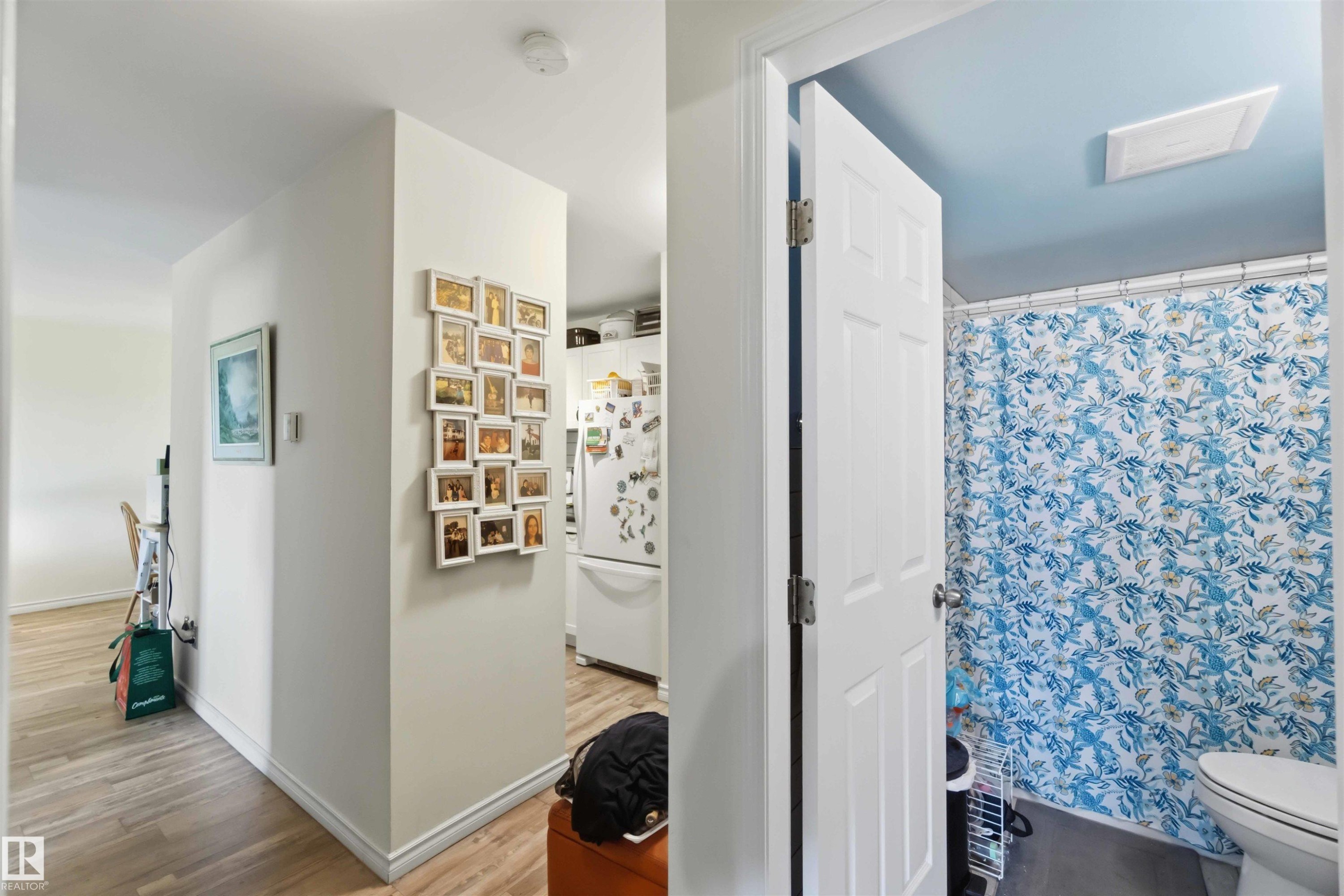 Bathroom featuring a blue ceiling, white trim, and a patterned shower curtain - 204 4601 131 Avenue, Edmonton, AB