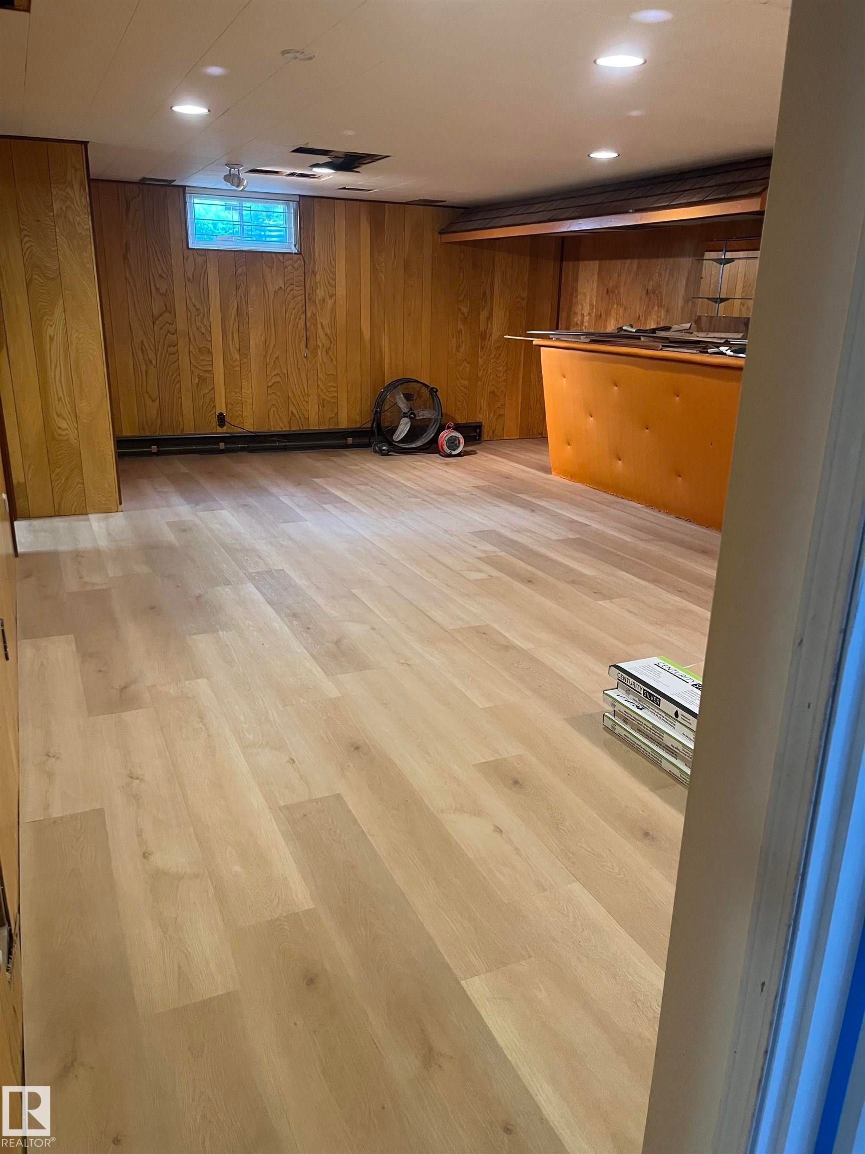 Expansive room featuring light wood-finish flooring, recessed ceiling lighting, and wood paneling - 8736 72 Street Nw, Edmonton, AB - Indoor