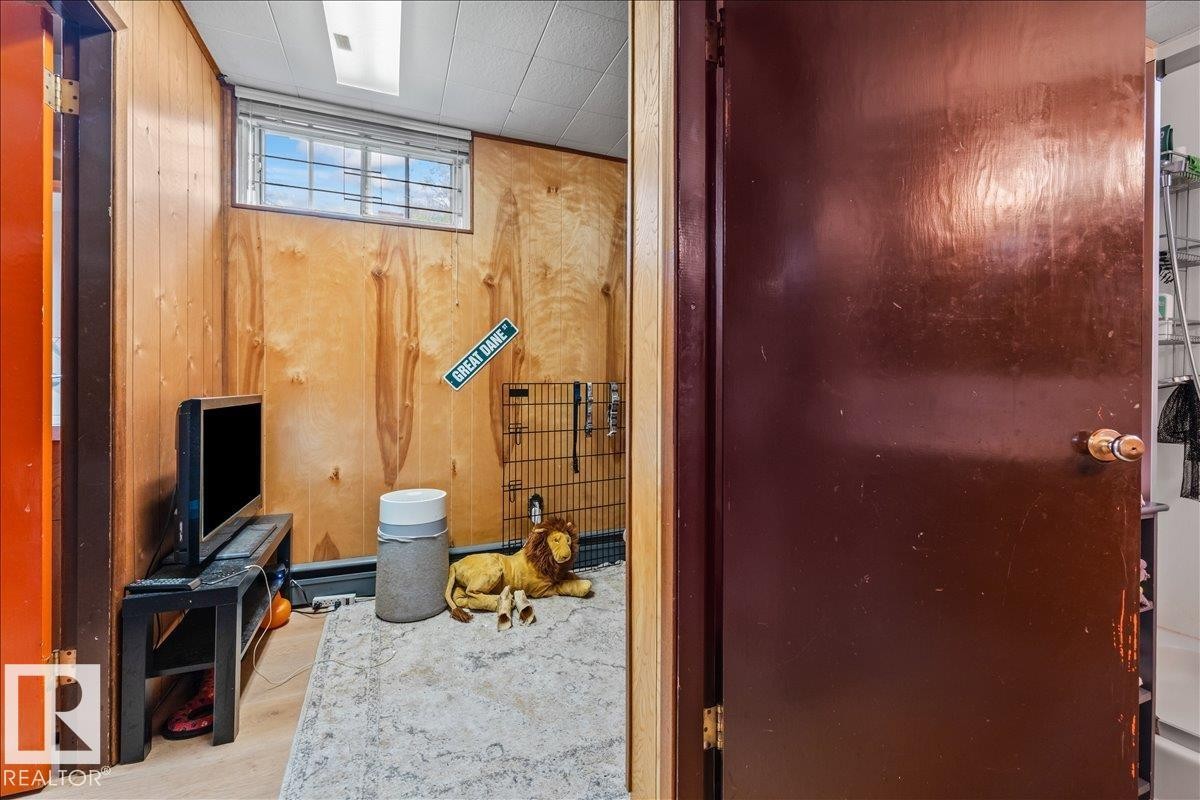 Room featuring wood paneling, a single-pane window, and a drop ceiling with recessed lighting - 8736 72 Street Nw, Edmonton, AB - Indoor