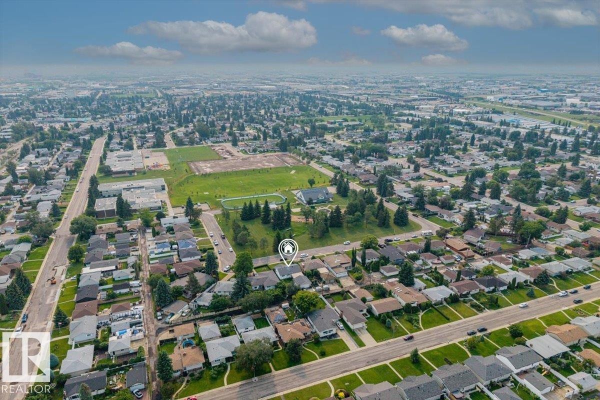 Expansive aerial perspective showcasing a residential neighborhood with numerous single-family homes, mature trees, and paved streets - 8736 72 Street Nw, Edmonton, AB - Outdoor With View