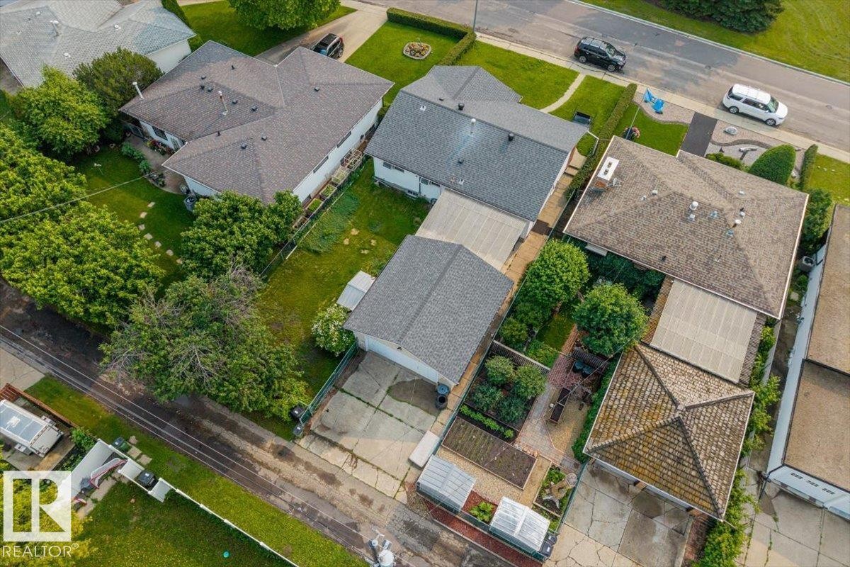 Single-story residence featuring a shingled roof, attached garage, and paved driveway - 8736 72 Street Nw, Edmonton, AB - Outdoor With View