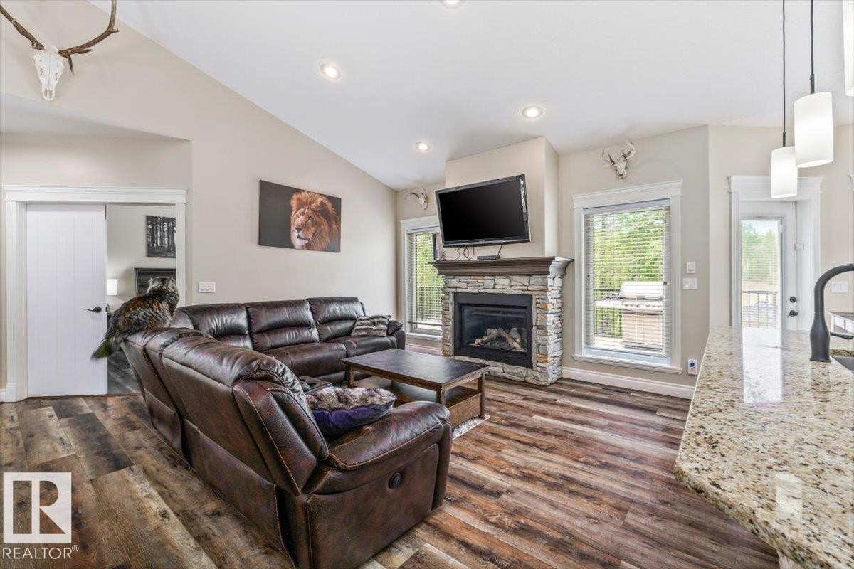Open-concept living area featuring vaulted ceilings and wood-finish flooring - #6 2406 Twp Road 540, Rural Lac Ste. Anne County, AB - Indoor Photo Showing Living Room With Fireplace