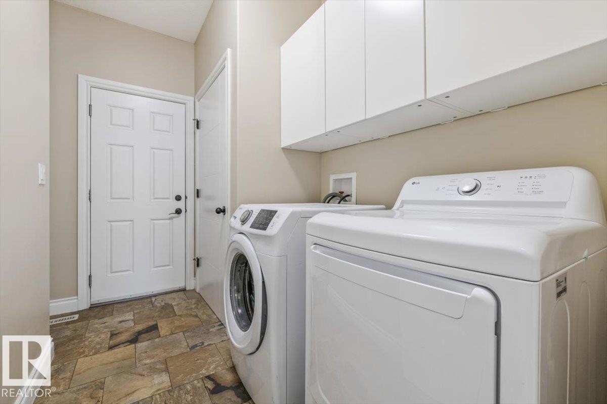 Laundry area featuring tiled flooring, overhead white cabinetry, and light neutral wall paint - #6 2406 Twp Road 540, Rural Lac Ste. Anne County, AB - Indoor Photo Showing Laundry Room