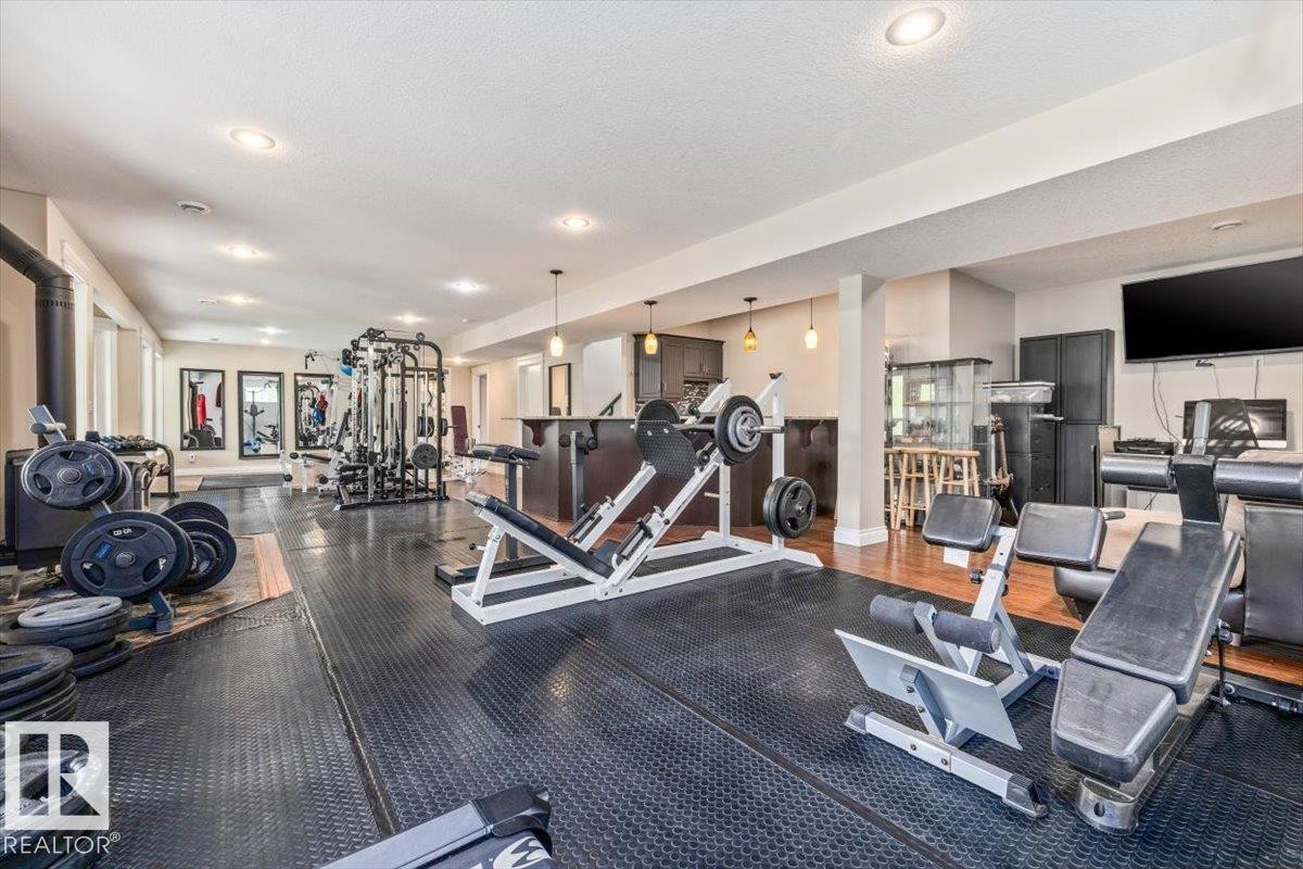 Dedicated fitness space featuring rubber flooring, recessed lighting, and a built-in wet bar with pendant lighting - #6 2406 Twp Road 540, Rural Lac Ste. Anne County, AB - Indoor Photo Showing Gym Room