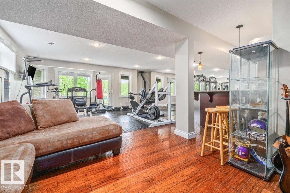 Expansive lower level featuring rich wood-finish flooring, recessed lighting, and a dedicated fitness area - #6 2406 Twp Road 540, Rural Lac Ste. Anne County, AB - Indoor