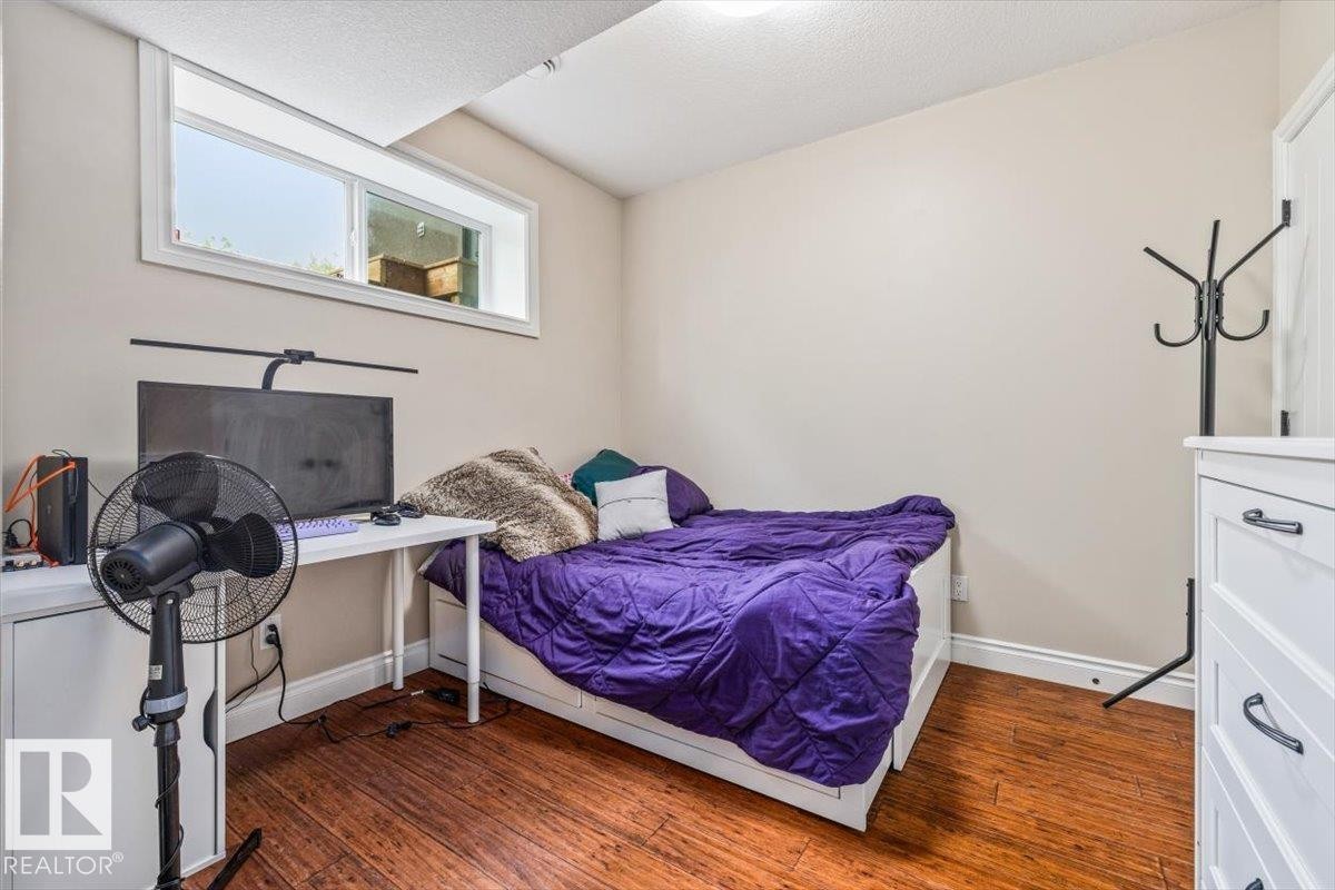 Lower-level room with a horizontal window and wood-finish flooring - #6 2406 Twp Road 540, Rural Lac Ste. Anne County, AB - Indoor Photo Showing Bedroom