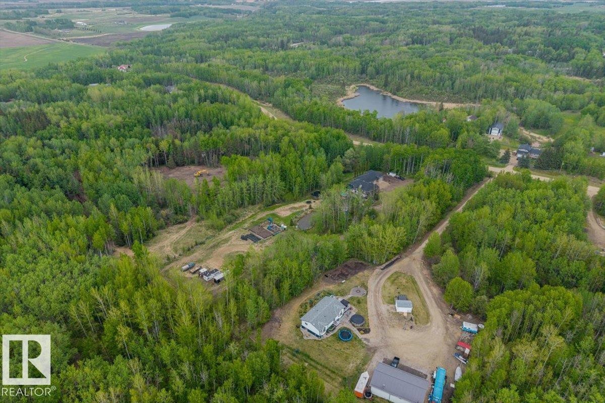 Expansive wooded property featuring a natural pond, multiple residential structures, cleared land areas, and direct road access - #6 2406 Twp Road 540, Rural Lac Ste. Anne County, AB - Outdoor With View