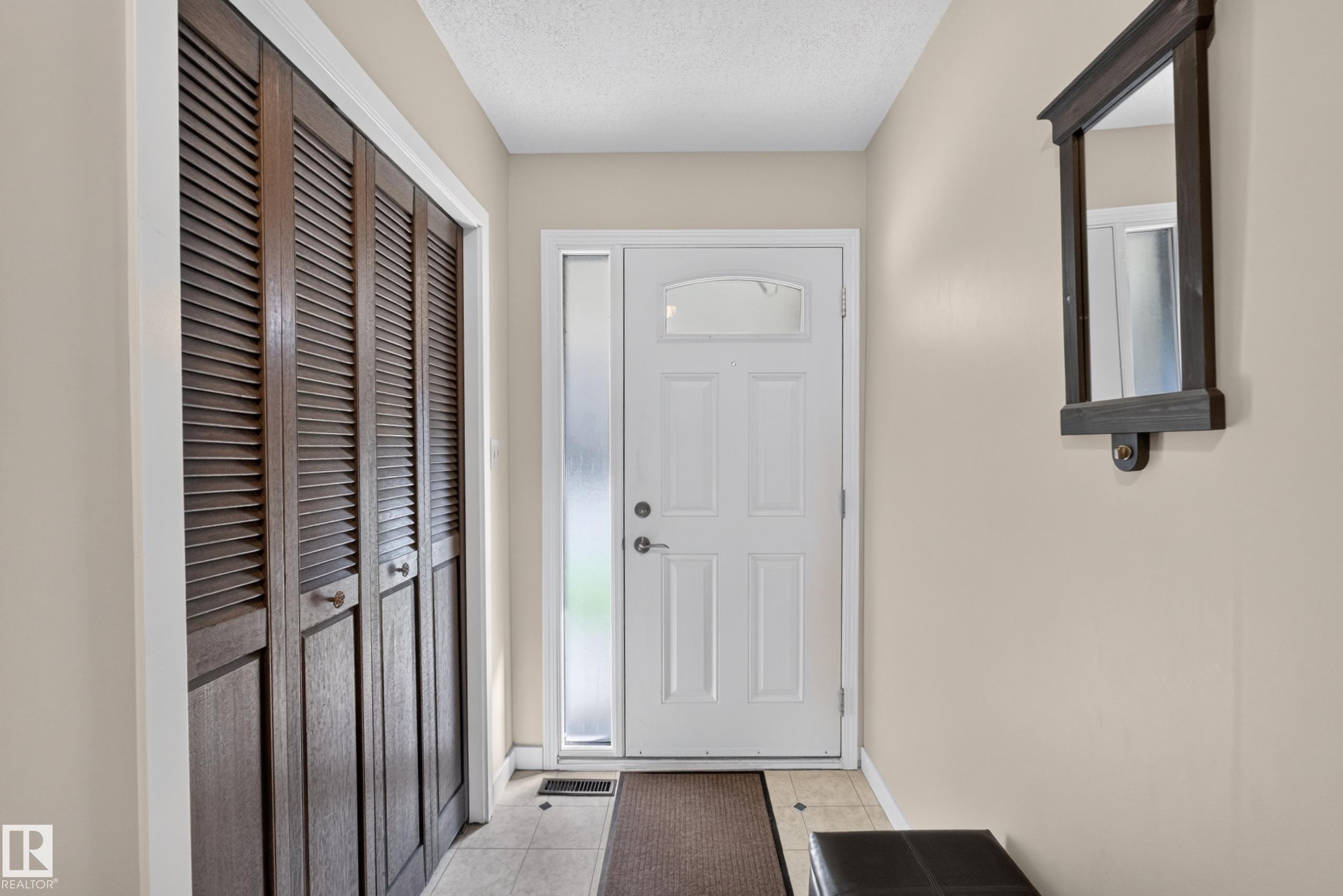 Entryway featuring a white paneled front door, frosted sidelight, and ceramic tile flooring - 12062 157 Avenue, Edmonton, AB