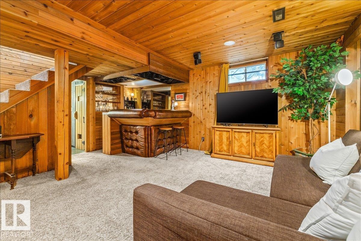Finished basement featuring wood paneling, wood-beamed ceiling, and light-toned carpeting - 11603 70 Street Nw, Edmonton, AB