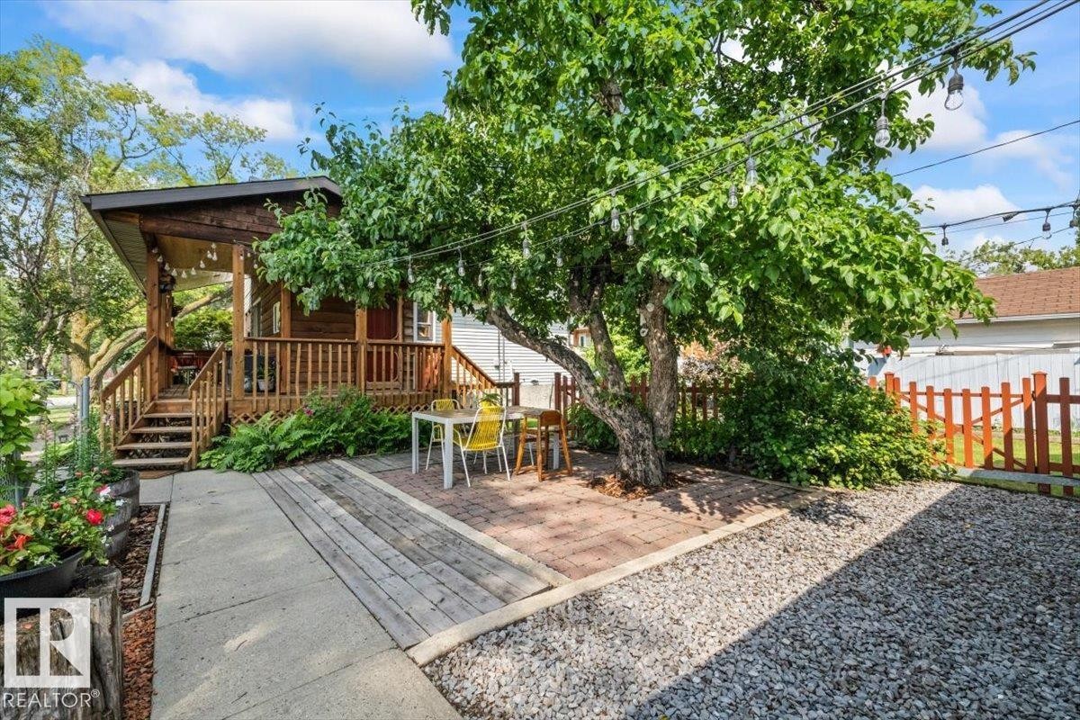 Expansive outdoor living area featuring a wood-plank deck, wood railings, and a covered porch - 11603 70 Street Nw, Edmonton, AB