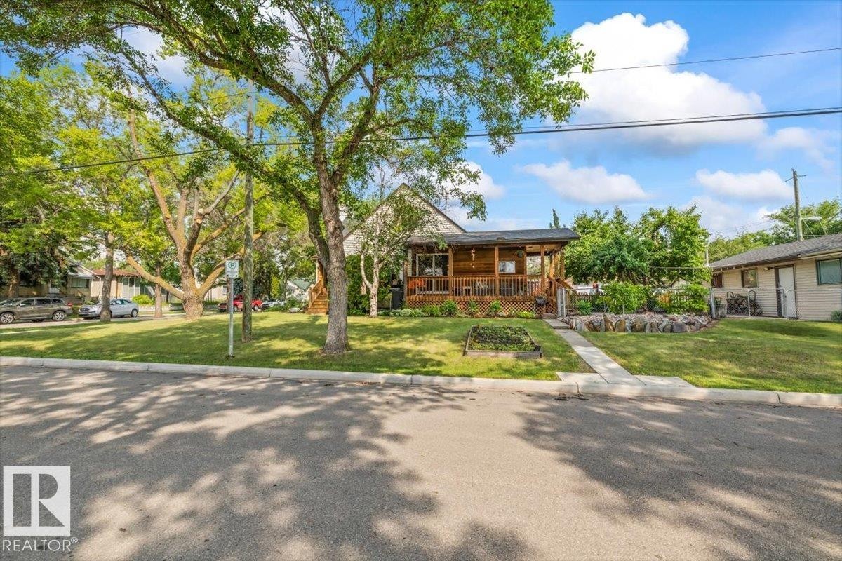 Lawn-front property featuring a wood-sided exterior and covered porch - 11603 70 Street Nw, Edmonton, AB