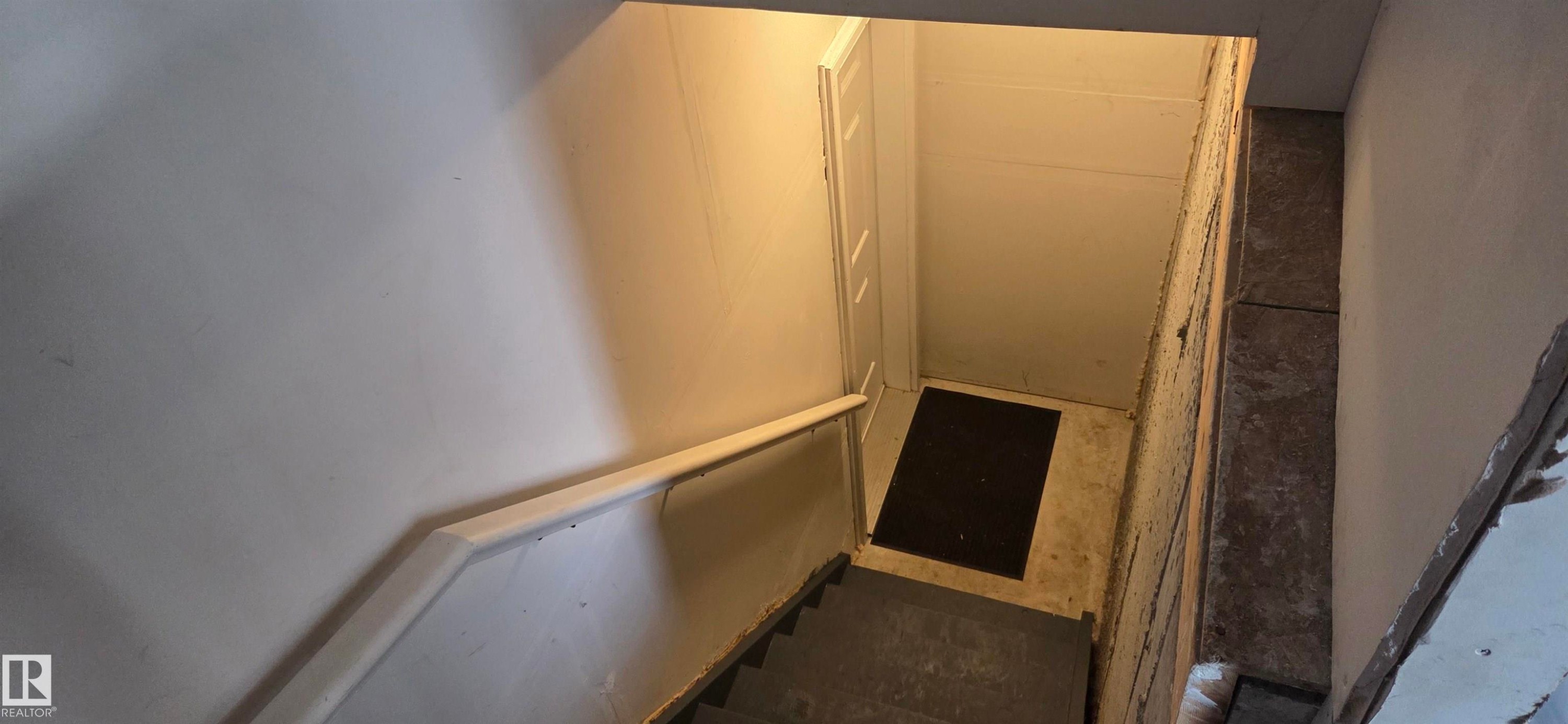 Stairwell featuring a painted handrail and concrete steps - 16505 133 Street, Edmonton, AB