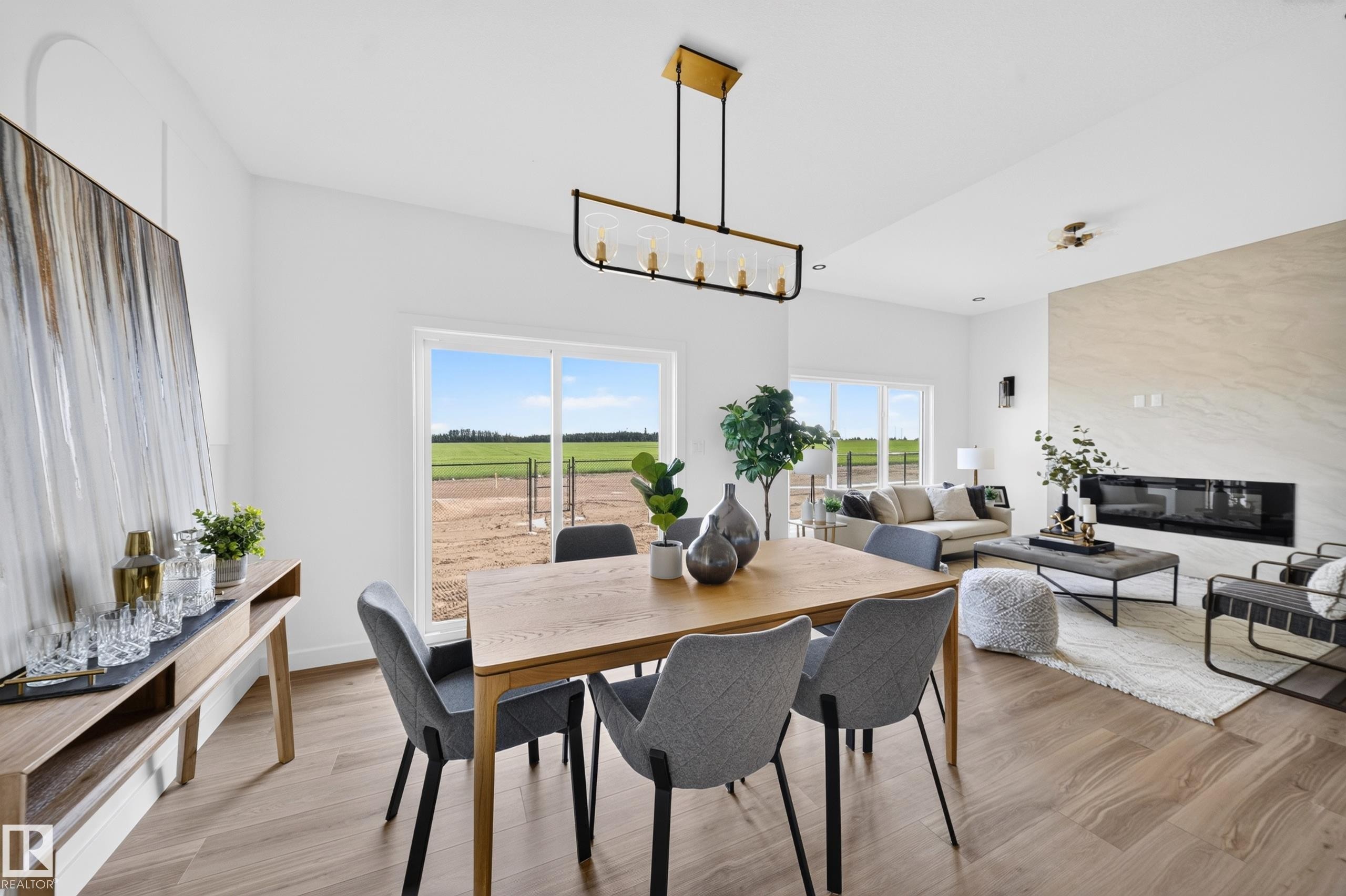 Open-concept living area featuring wood-finish flooring, a linear electric fireplace with a stone surround, and abundant natural light from large windows - 523 Ashgrove Circle, Leduc, AB