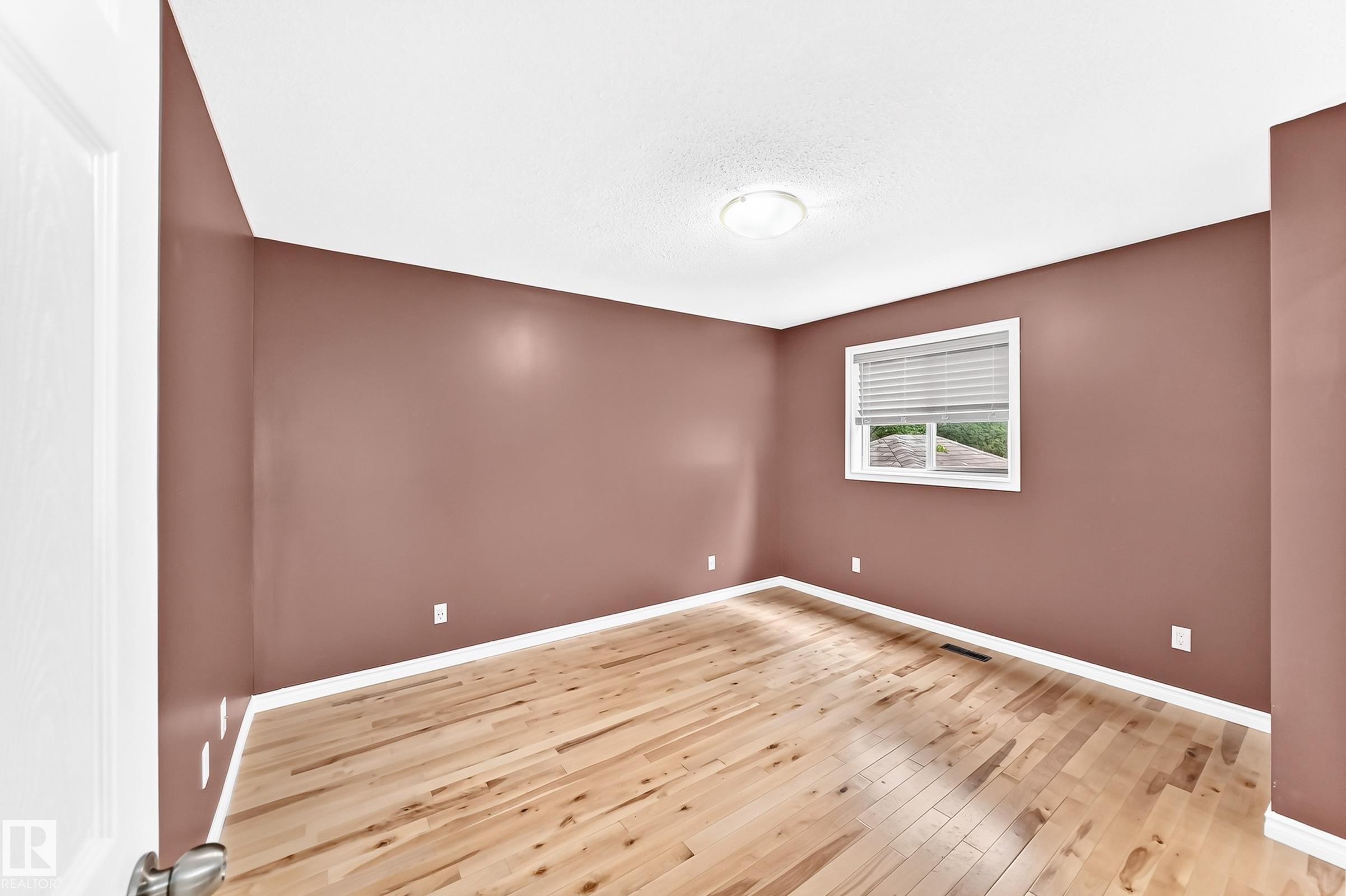 Bedroom featuring wood-finish flooring, a window with horizontal blinds, white baseboards, and a flush mount ceiling light fixture - 1763 48A Street, Edmonton, AB